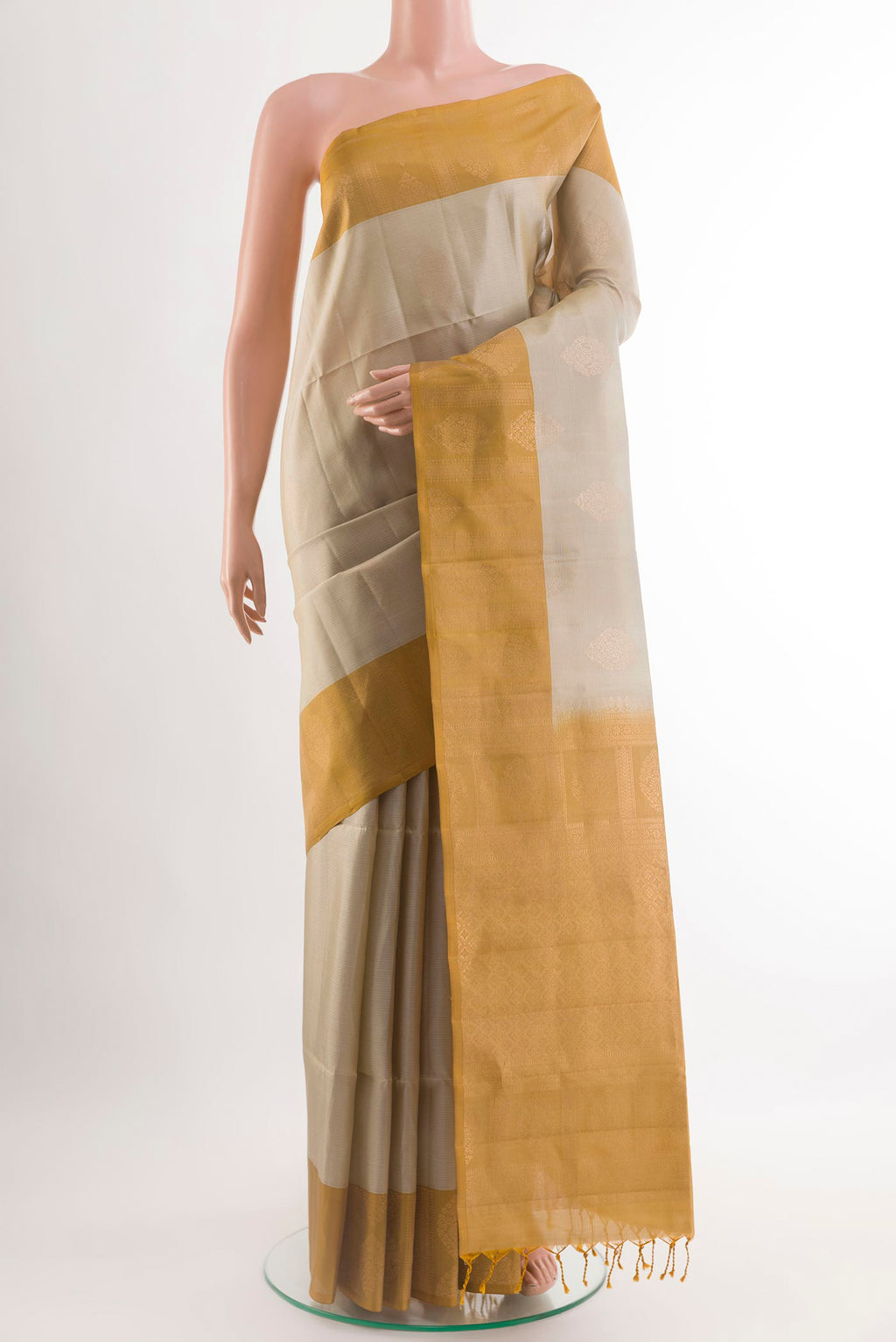 Cream Soft Silk Saree with Zari Butta on the body and Zari Border.  displayed on a mannequin