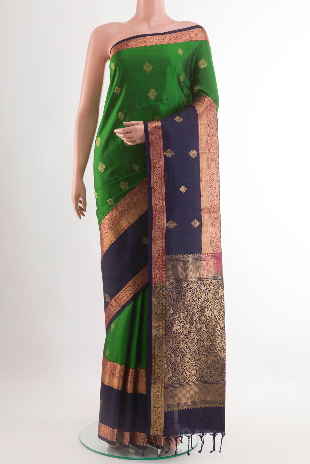 Green Soft Silk Saree with Zari Butta on the body and Zari Border.  displayed on a mannequin