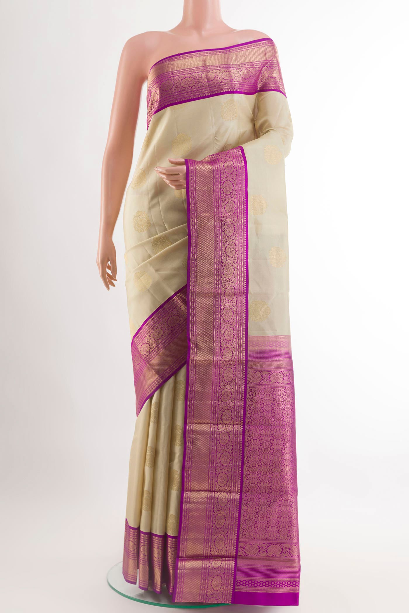 Beige Kanjivaram Silk Saree with Zari Butta on the body and Zari Border.  displayed on a mannequin