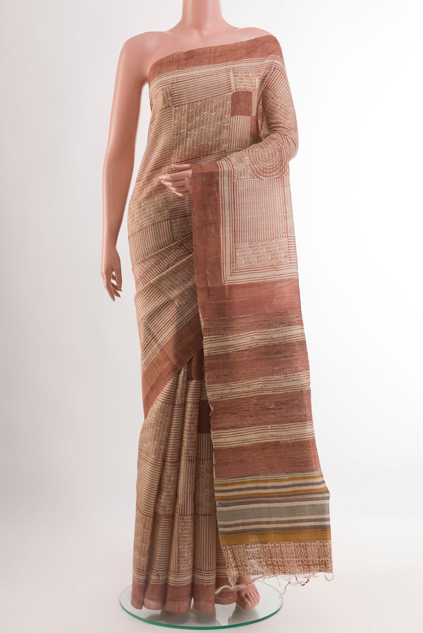 Brown Tussar Saree with Printed design on the body and Printed Border.  displayed on a mannequin