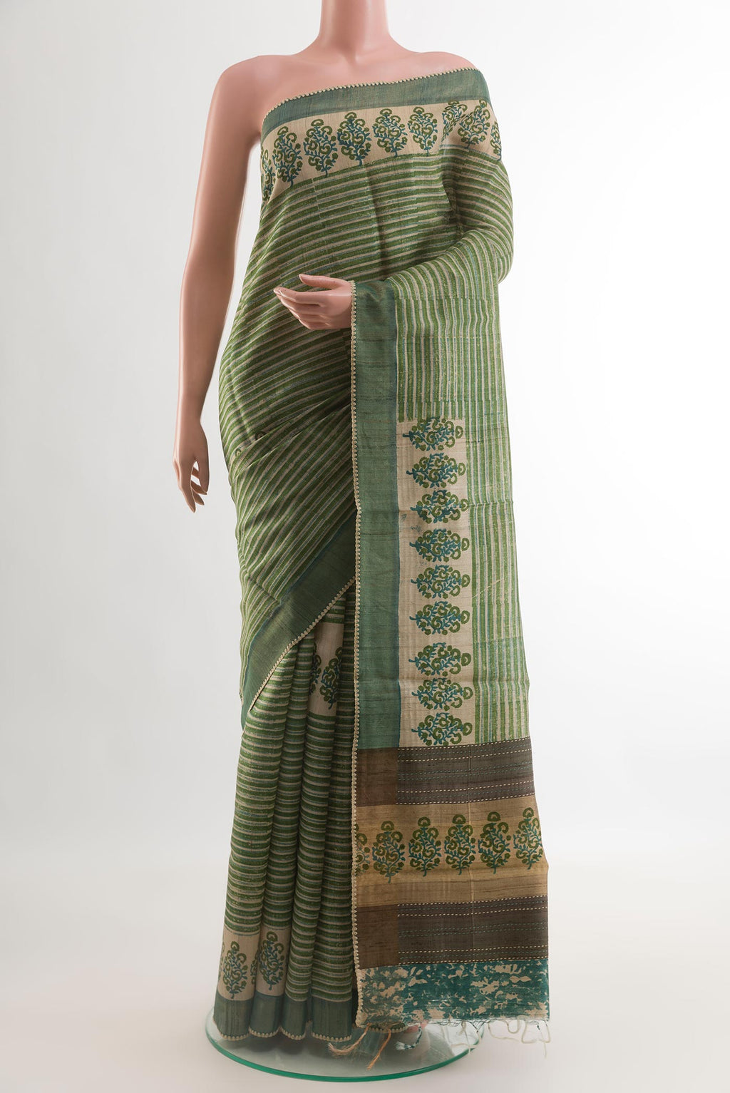 Green Tussar Silk Saree with Printed design on the body and Printed Border.  displayed on a mannequin