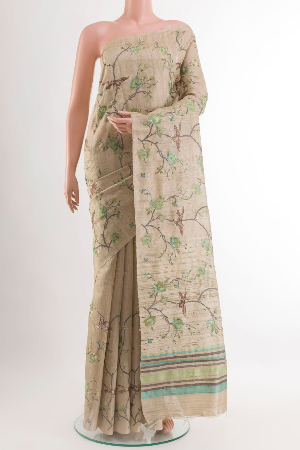 Beige Tussar Saree with Embroidery on the body and Embroidery Border.  displayed on a mannequin