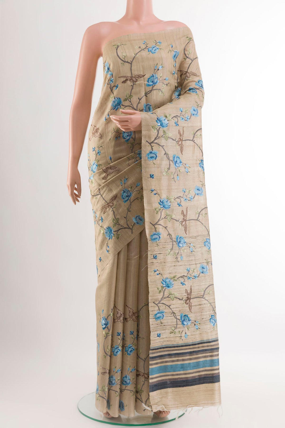 Beige Tussar Saree with Embroidery on the body and Embroidery Border.  displayed on a mannequin