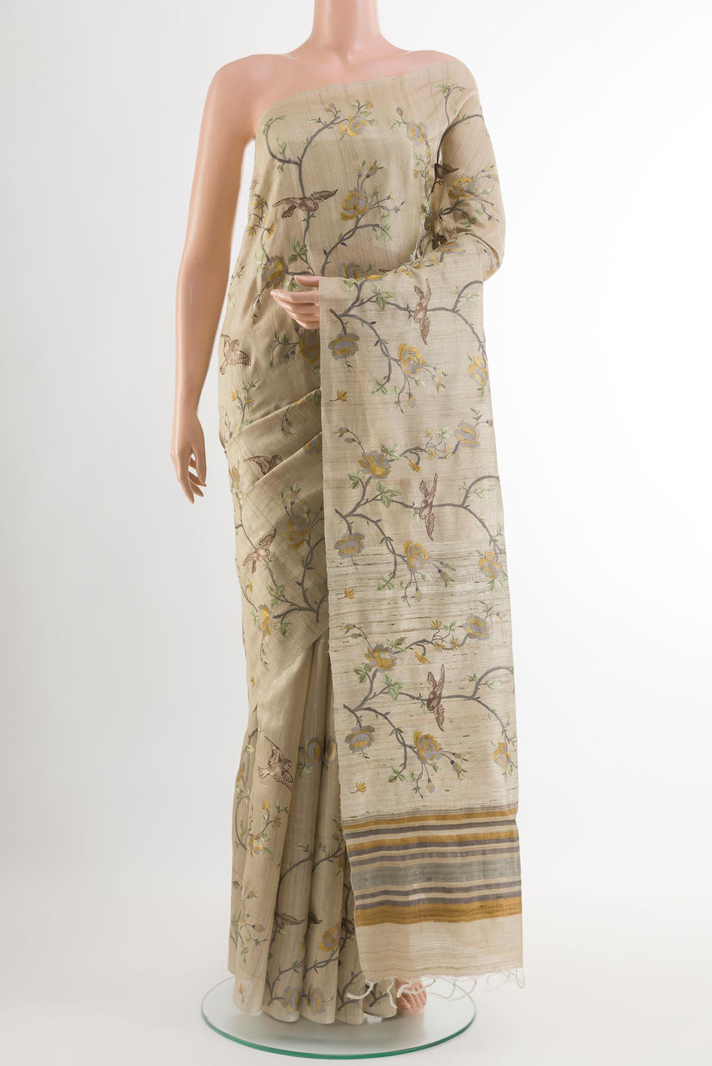 Beige Tussar Saree with Embroidery on the body and Embroidery Border.  displayed on a mannequin