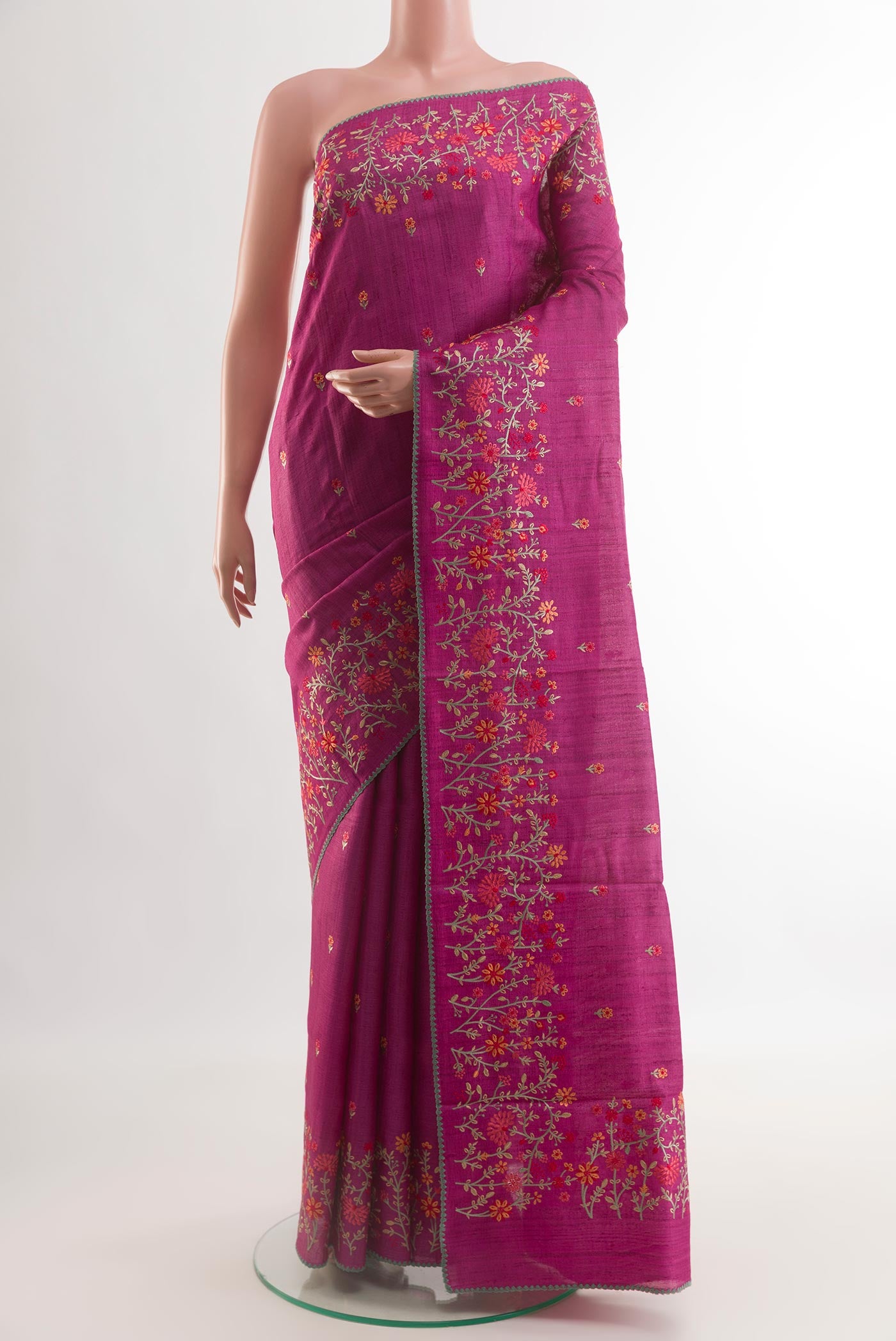 Magenta Tussar Silk Saree with Embroidery on the body and Embroidery Border.  displayed on a mannequin