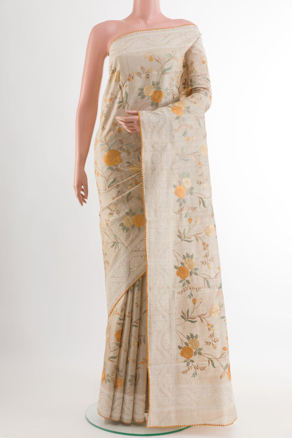 Cream Tussar Saree with Thread Butta on the body and Embroidery Border.  displayed on a mannequin
