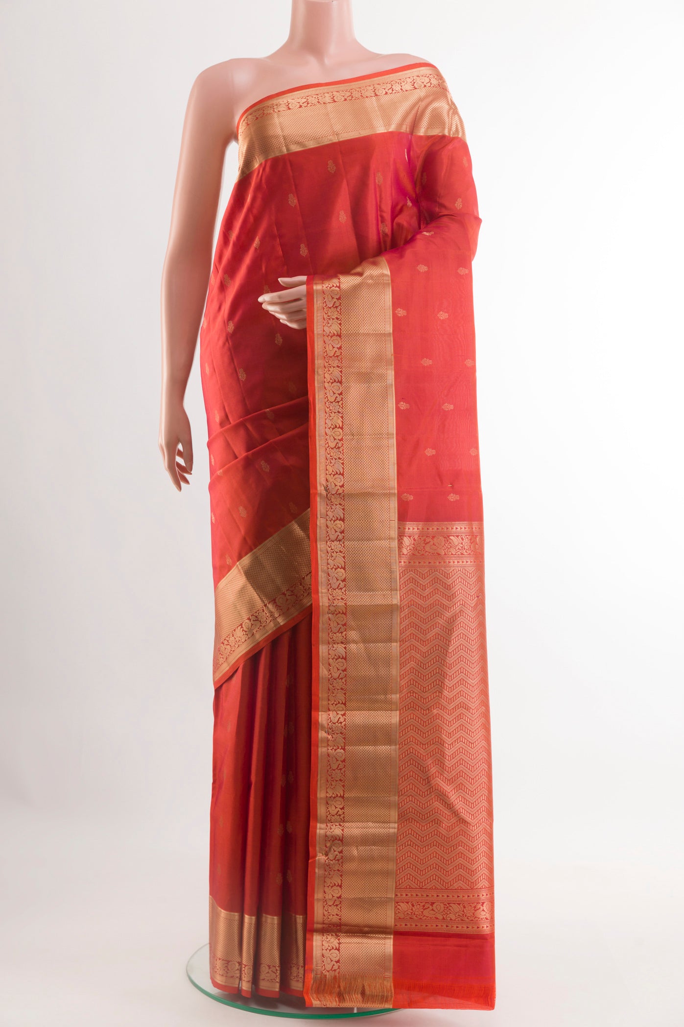Rust Kanjivaram Silk Saree with Zari Butta on the body and Zari Border.  displayed on a mannequin