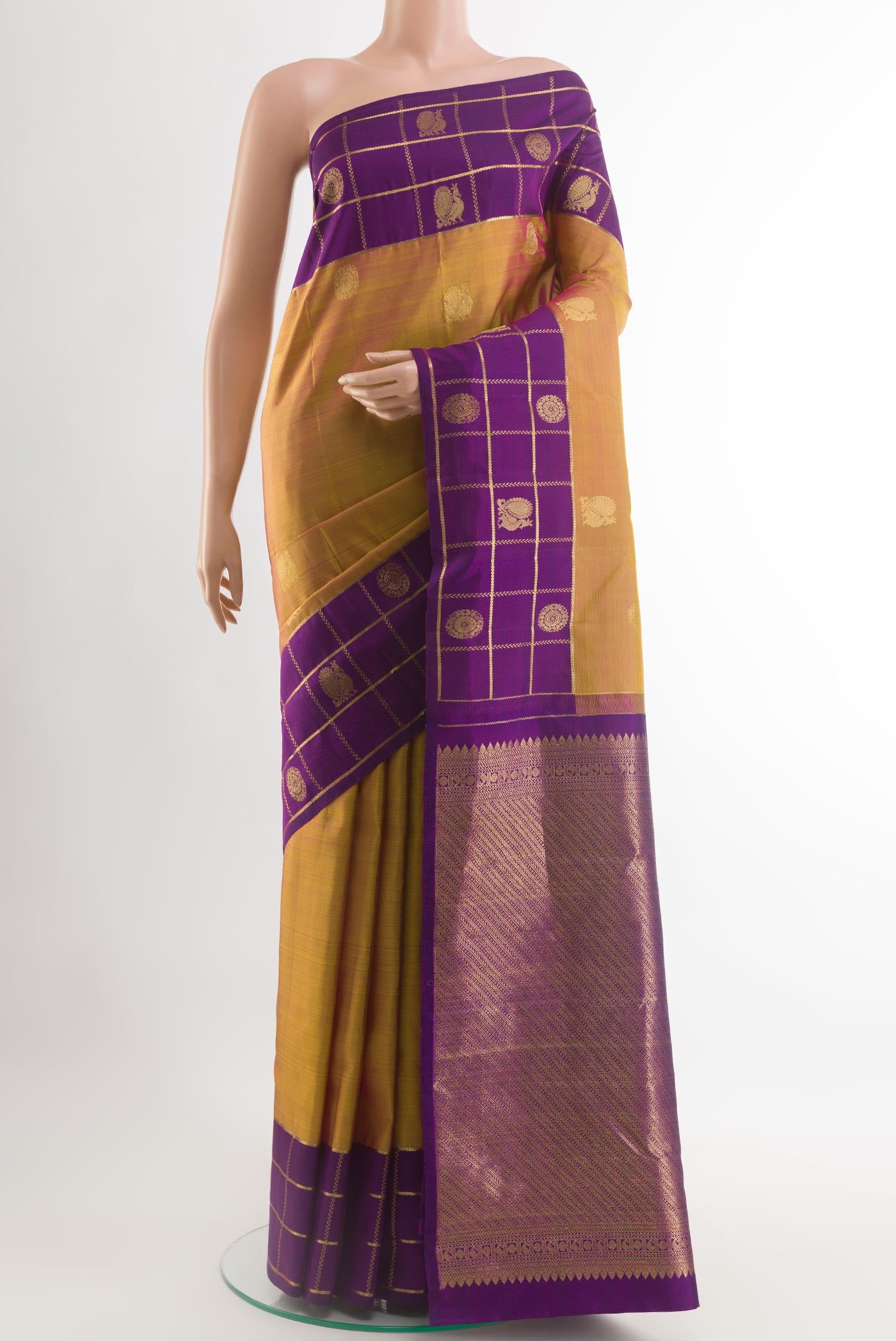 Mustard Kanjivaram Silk Saree with Zari Butta on the body and Zari Border.  displayed on a mannequin