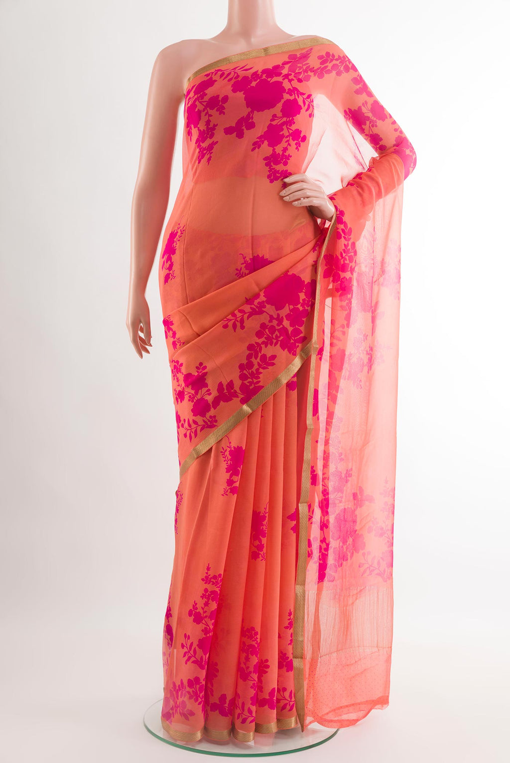 Orange Chiffon Saree with Printed design on the body and Plain Border.  displayed on a mannequin