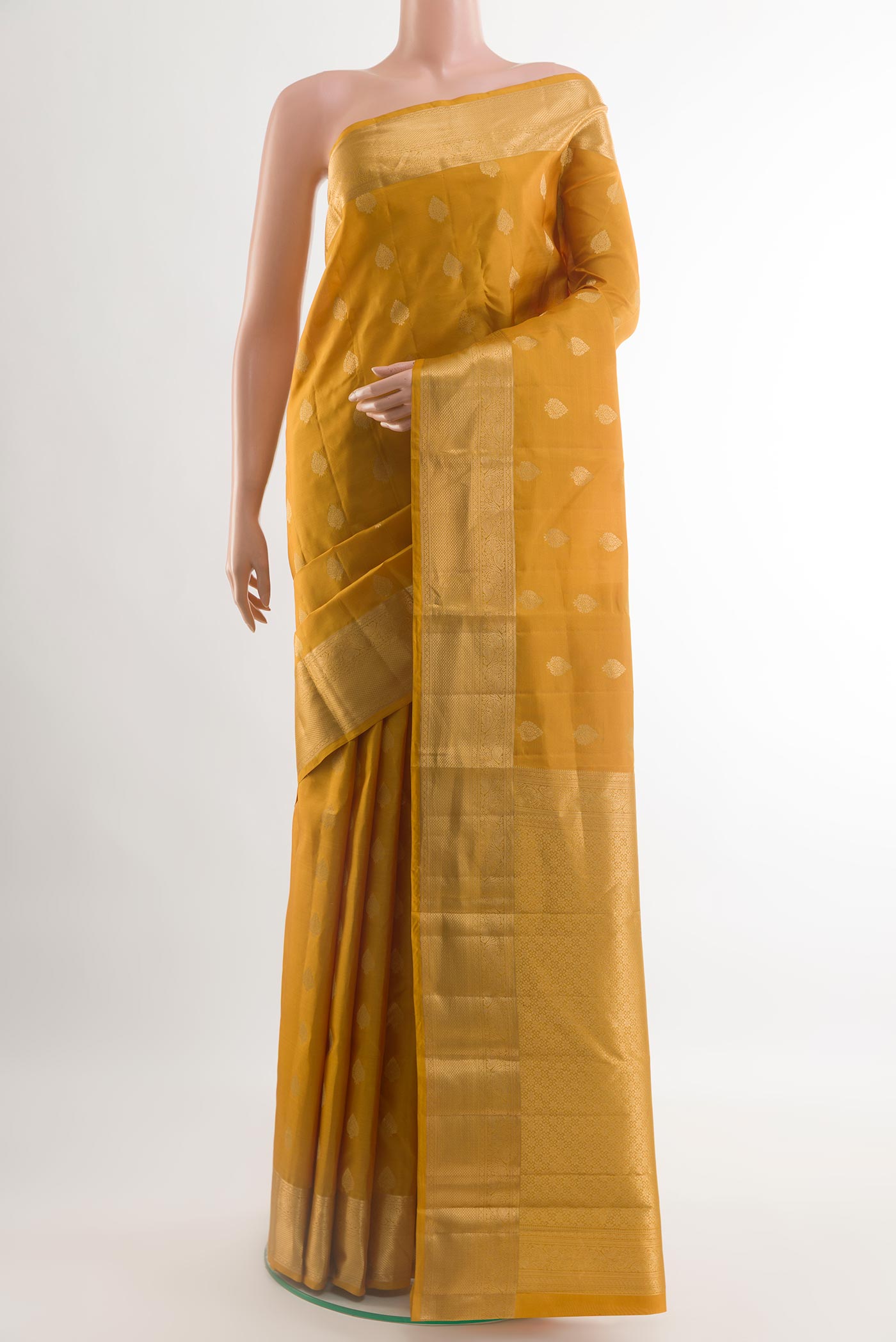 Yellow Kanchipuram Silk Saree with Zari Butta on the body and Zari Border.  displayed on a mannequin