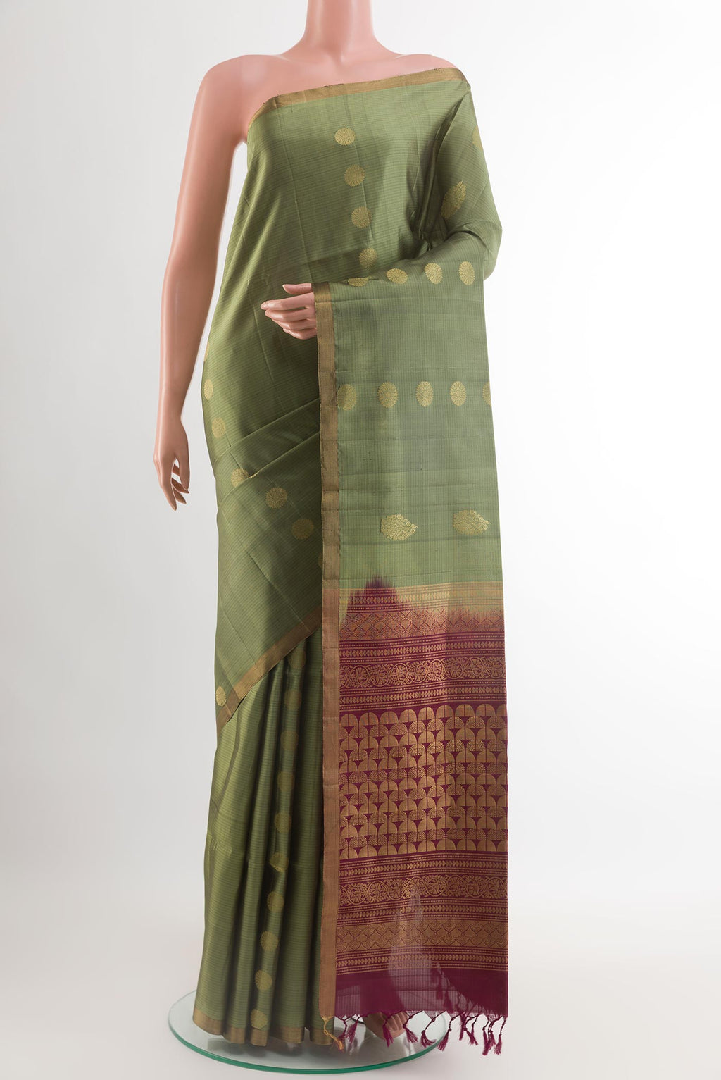 Mehandi Green Soft Silk Saree with Zari Butta on the body and Zari Border.  displayed on a mannequin