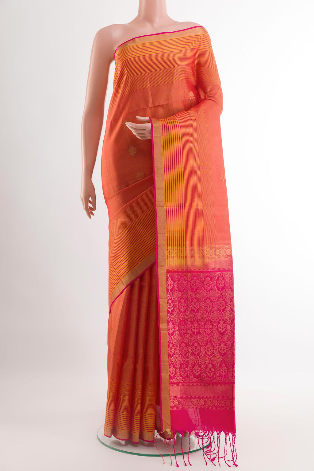 Brick Orange Soft Silk Saree with Zari Butta on the body and Zari Border.  displayed on a mannequin
