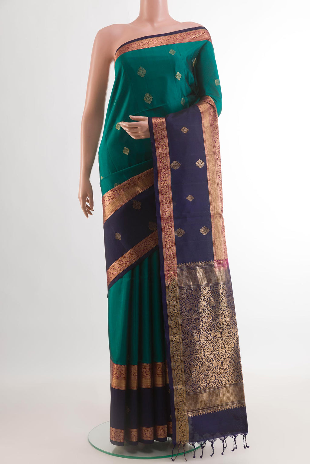 Green Soft Silk Saree with Zari Butta on the body and Zari Border.  displayed on a mannequin