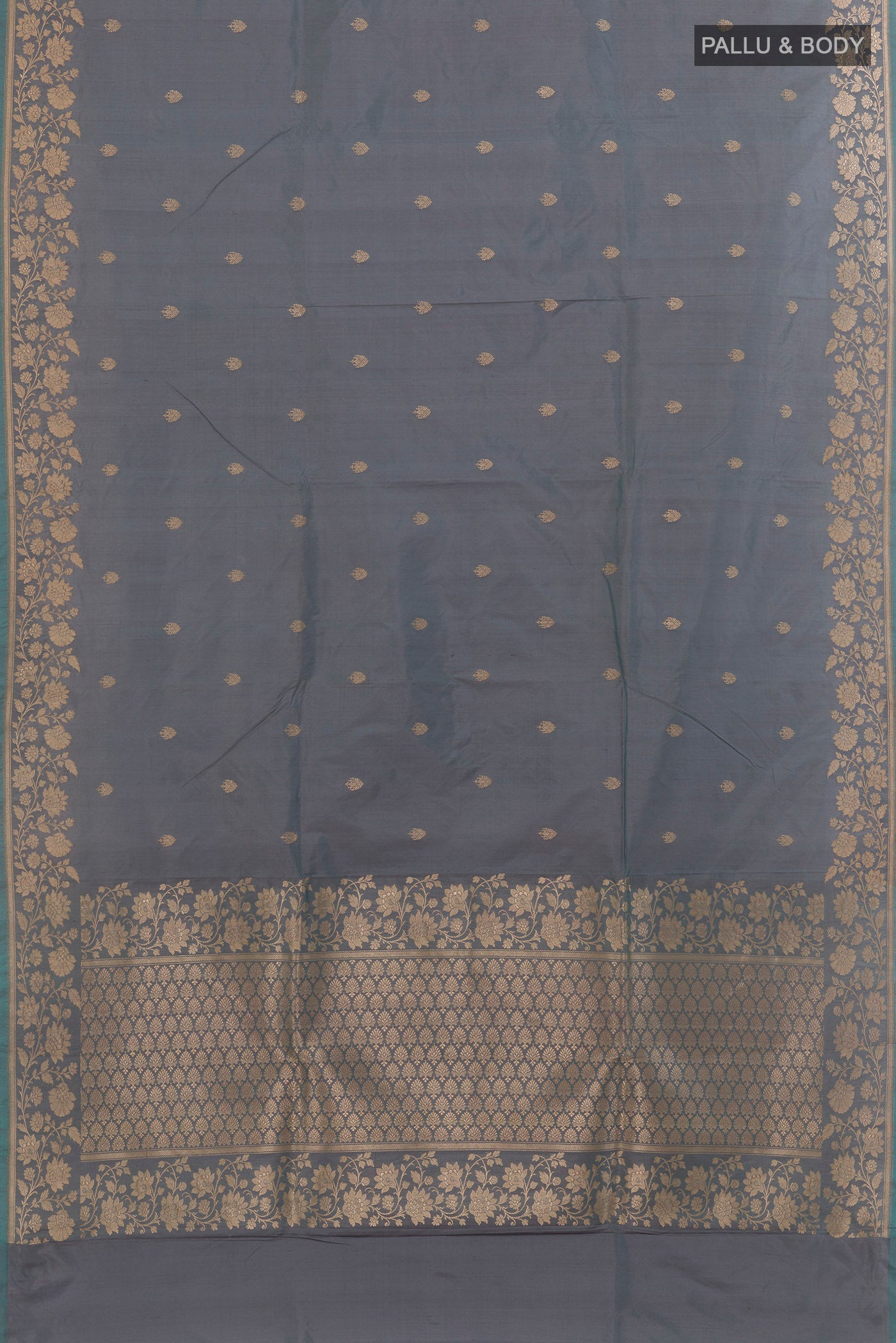 Flat view of Grey Banarasi Katan Silk Saree with Zari Butta on the body and Zari Border. 