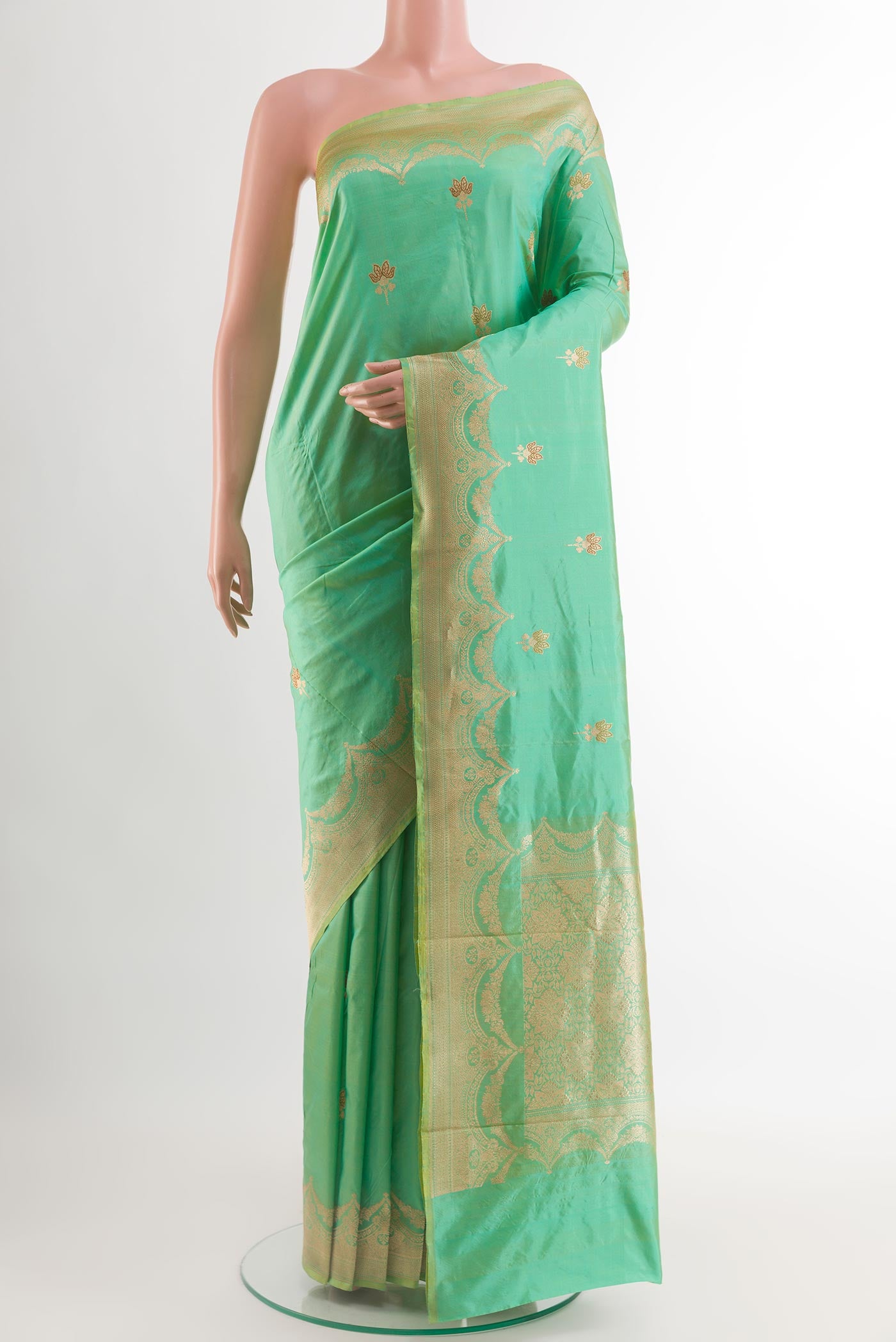 Green Banarasi Katan Silk Saree with Zari Butta on the body and Zari Border.  displayed on a mannequin