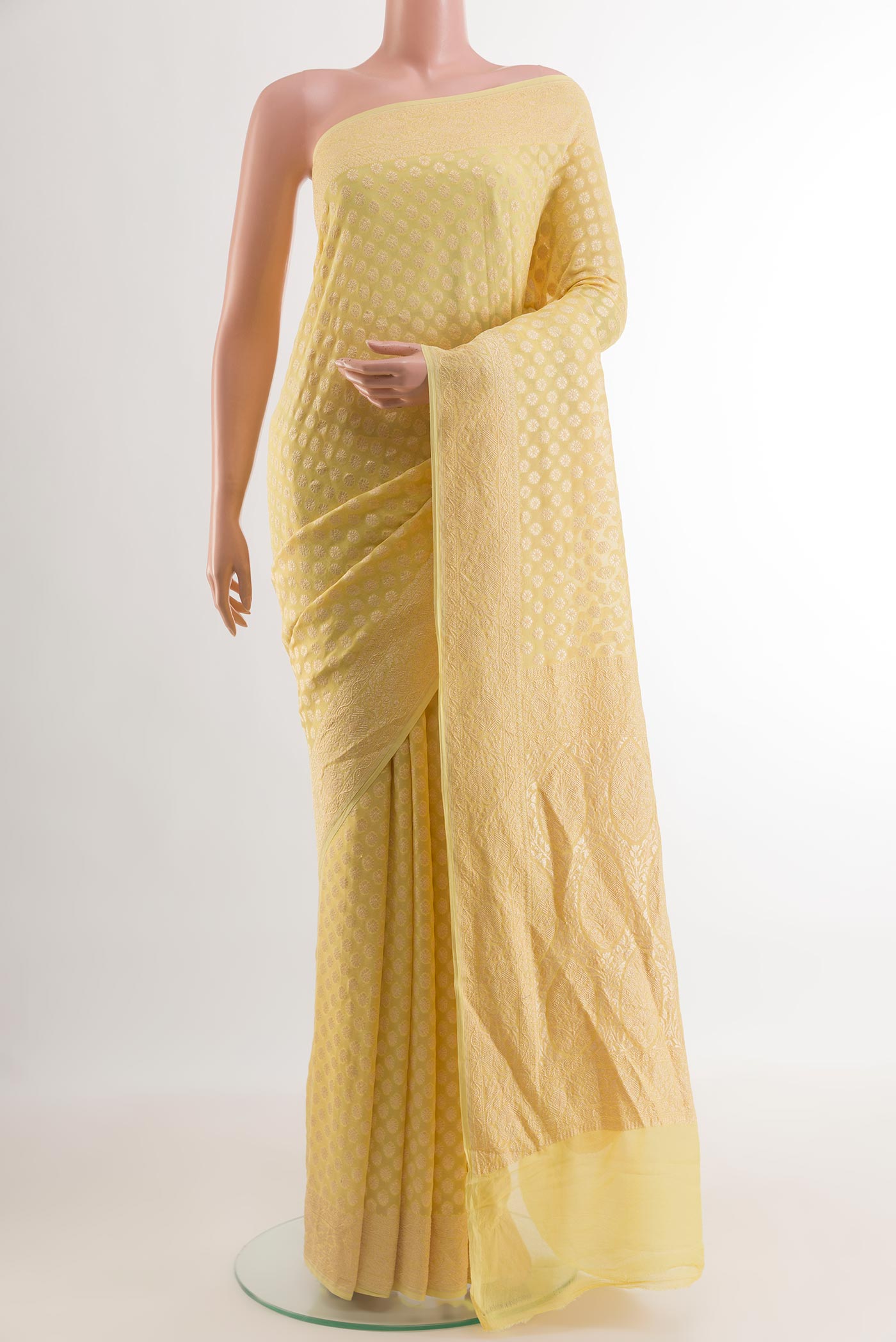 Yellow Banarasi Georgette Saree with Zari Butta on the body and Zari Border.  displayed on a mannequin