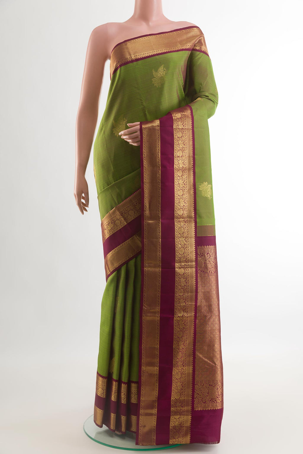 Green Kanjivaram Silk Saree with Zari Butta on the body and Zari Border.  displayed on a mannequin