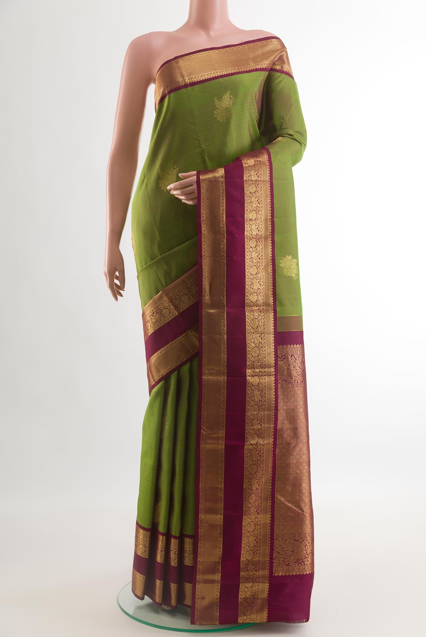 Green Kanjivaram Silk Saree with Zari Butta on the body and Zari Border.  displayed on a mannequin