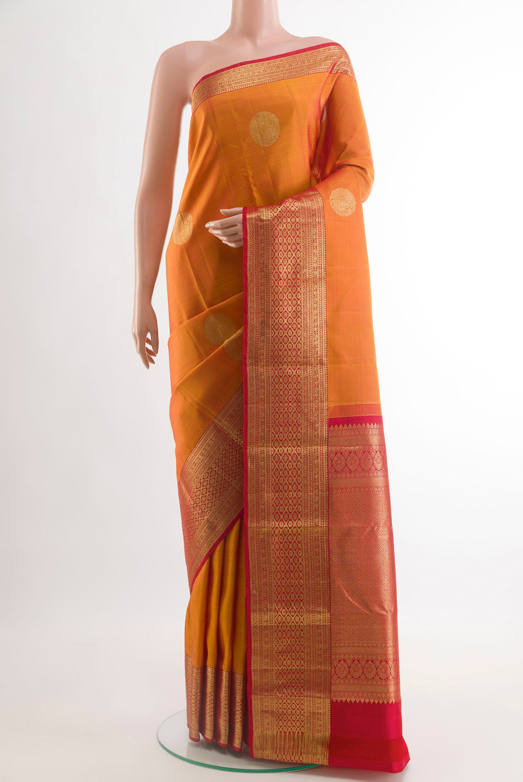 Brick Orange Kanchipuram Silk Saree with Zari Butta on the body and Zari Border.  displayed on a mannequin