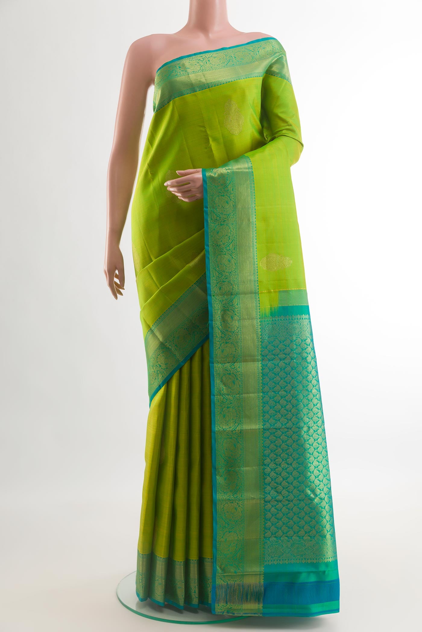 Green Kanchipuram Silk Saree with Zari Butta on the body and Zari Border.  displayed on a mannequin