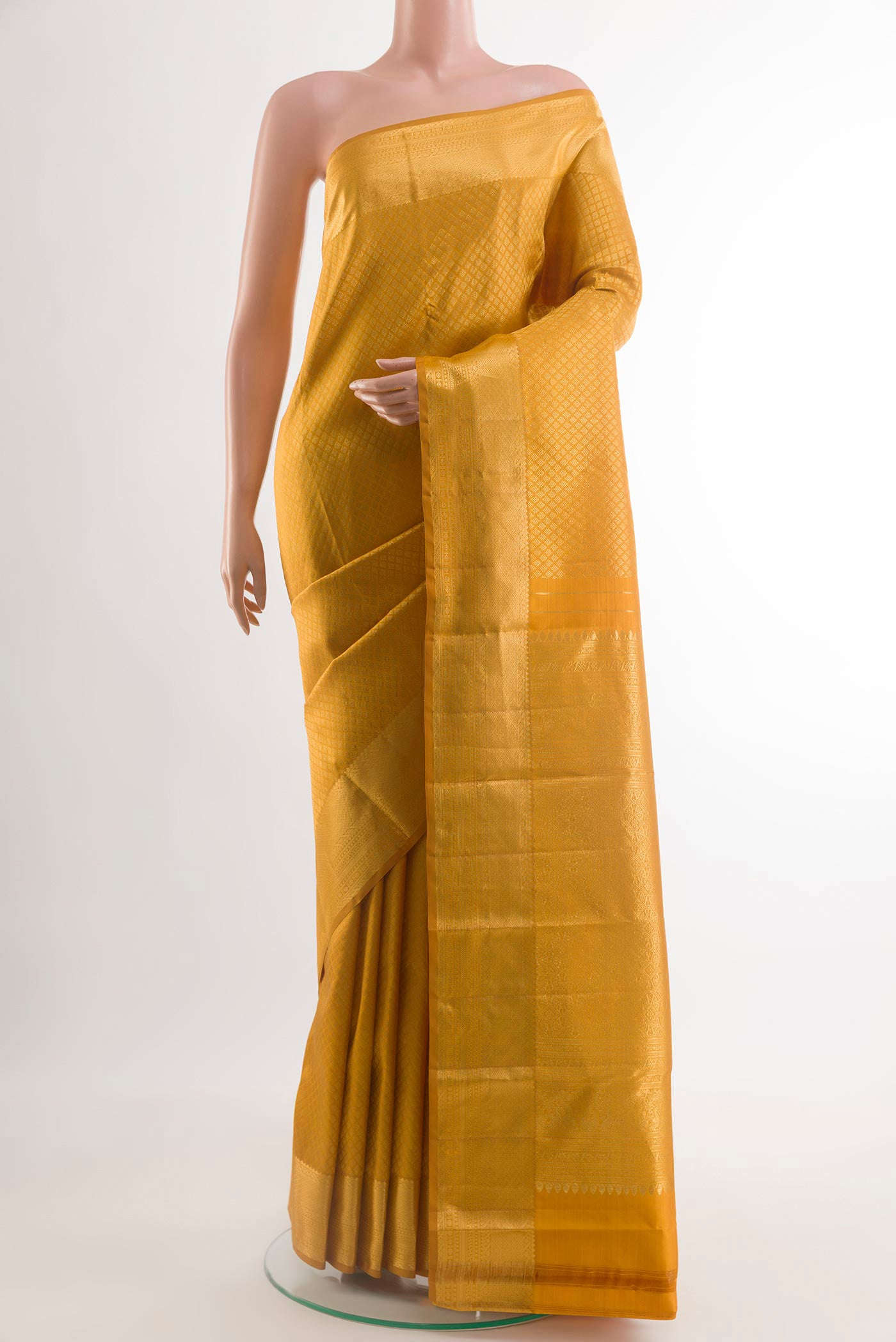 Mustard Kanjivaram Silk Saree with Zari Brocade on the body and Zari Border.  displayed on a mannequin