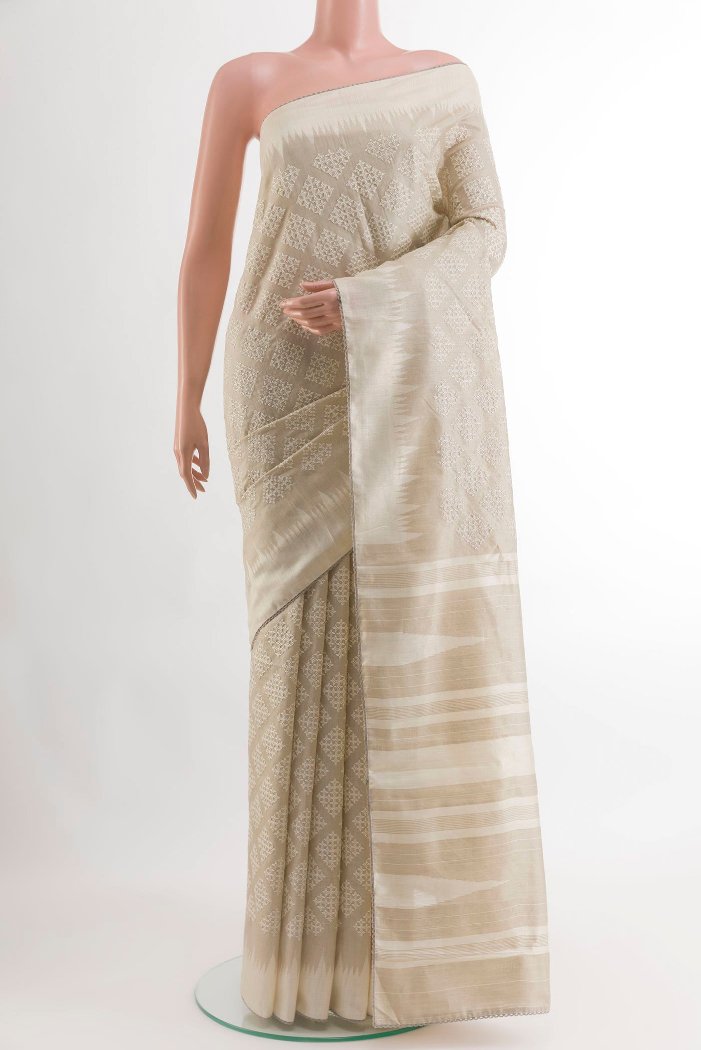 Off White Tussar Silk Saree with Embroidery on the body and Embroidery Border.  displayed on a mannequin