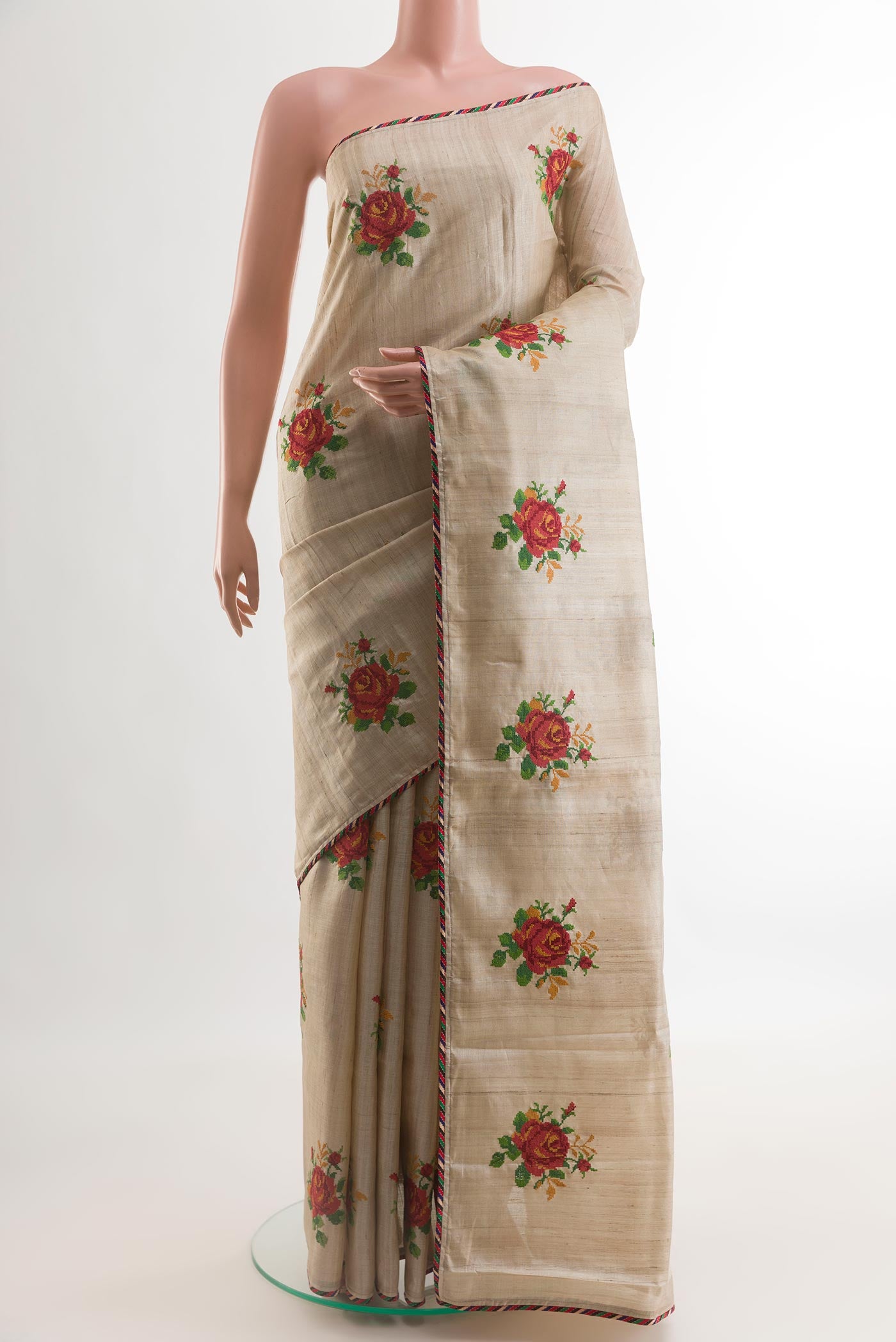 Beige Tussar Silk Saree with Embroidery on the body and Embroidery Border.  displayed on a mannequin