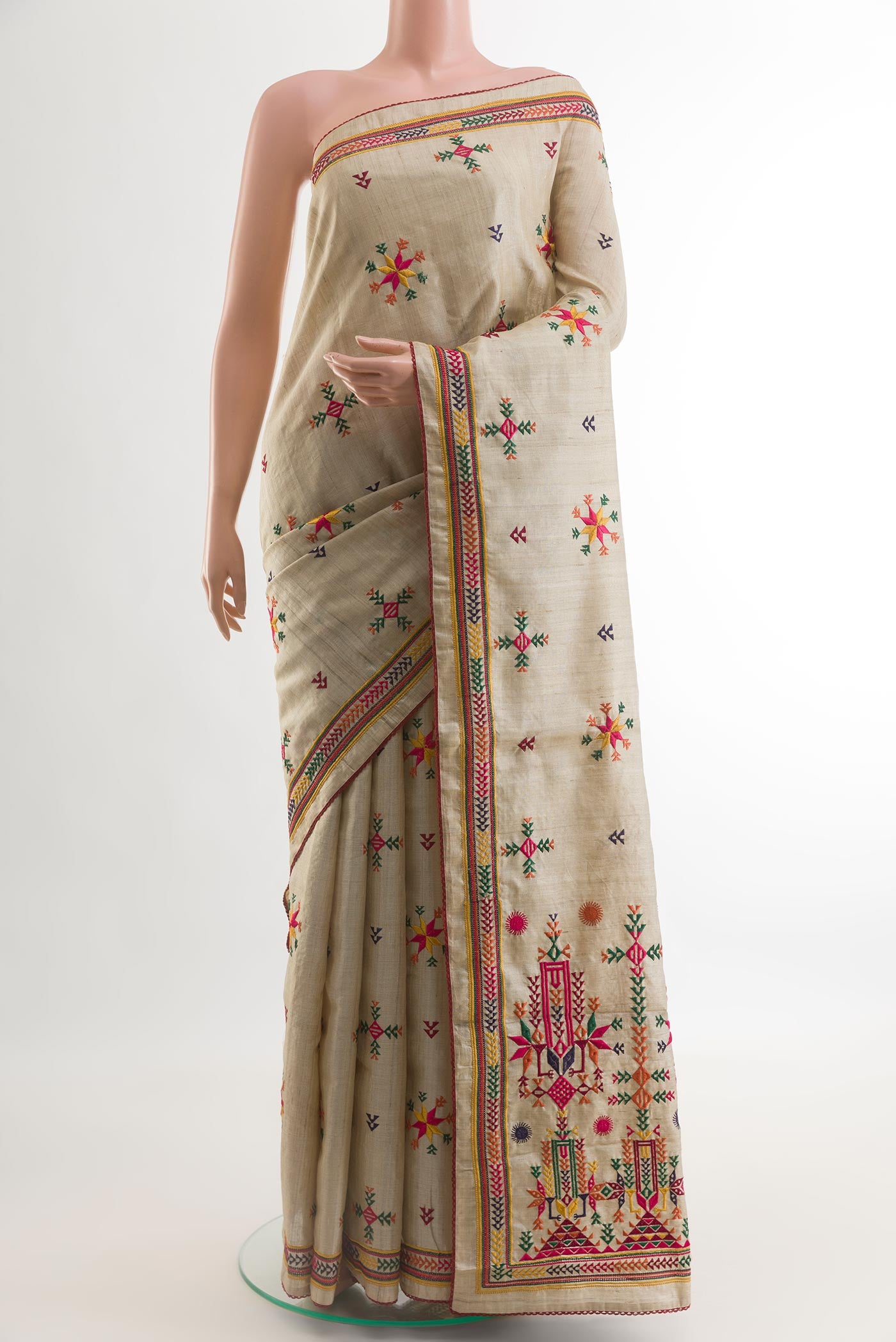 Beige Tussar Silk Saree with Embroidery on the body and Embroidery Border.  displayed on a mannequin