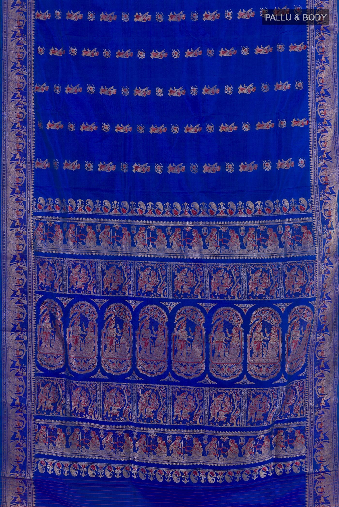 Flat view of Royal Blue Baluchari Silk Saree with Zari And Thread Butta on the body and Zari Border. 