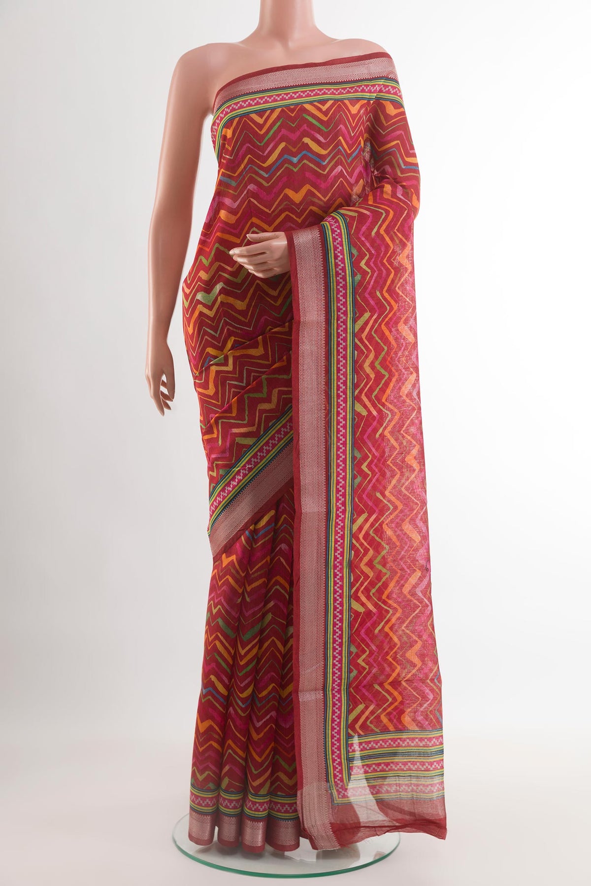 Red Tussar Saree with Printed design on the body and Zari Border.  displayed on a mannequin