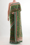 Green Tussar Silk Saree with Printed design on the body and Zari Border.  displayed on a mannequin