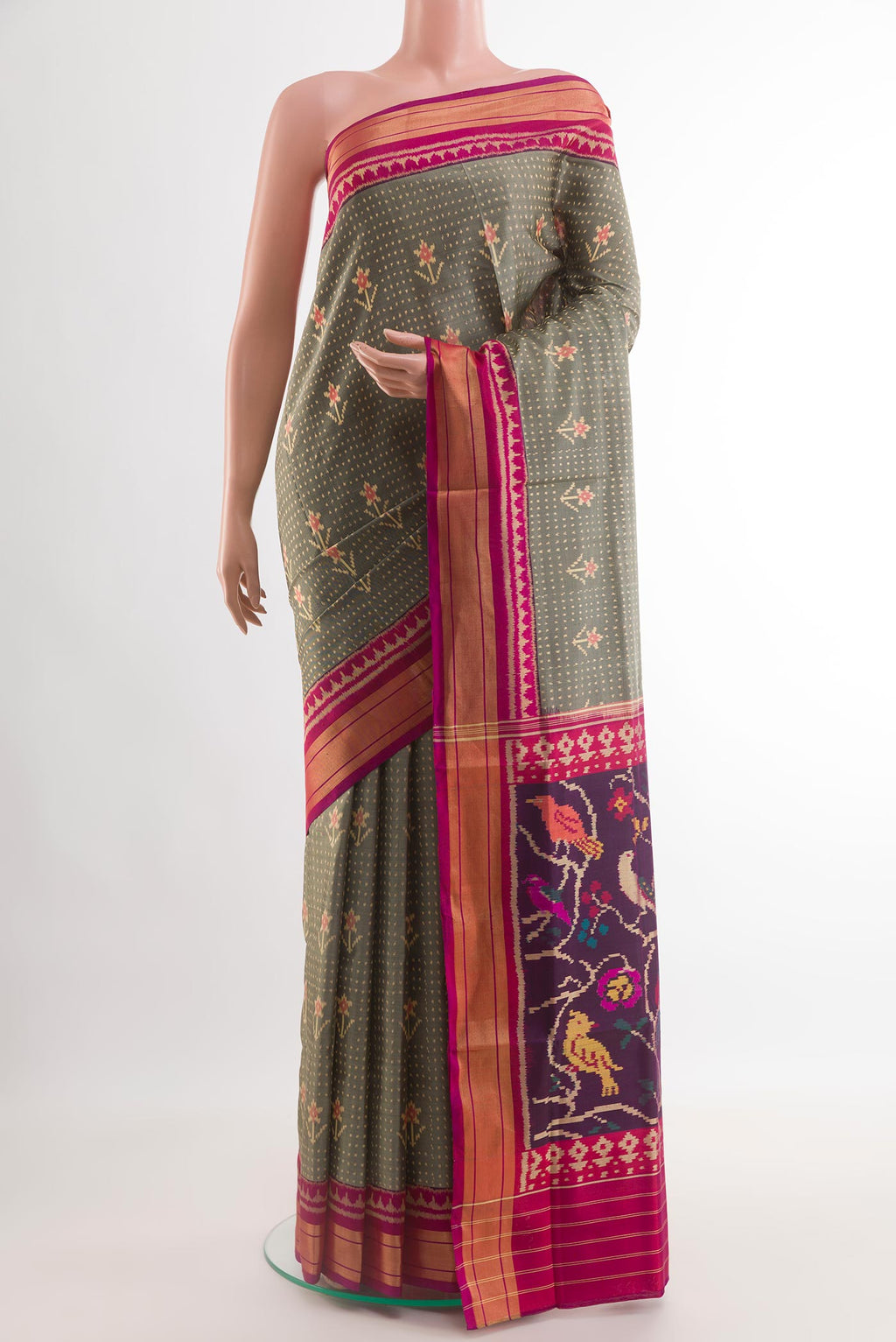 Grey Rajkot Patola Silk Saree with Ikat design on the body and Zari Border.  displayed on a mannequin