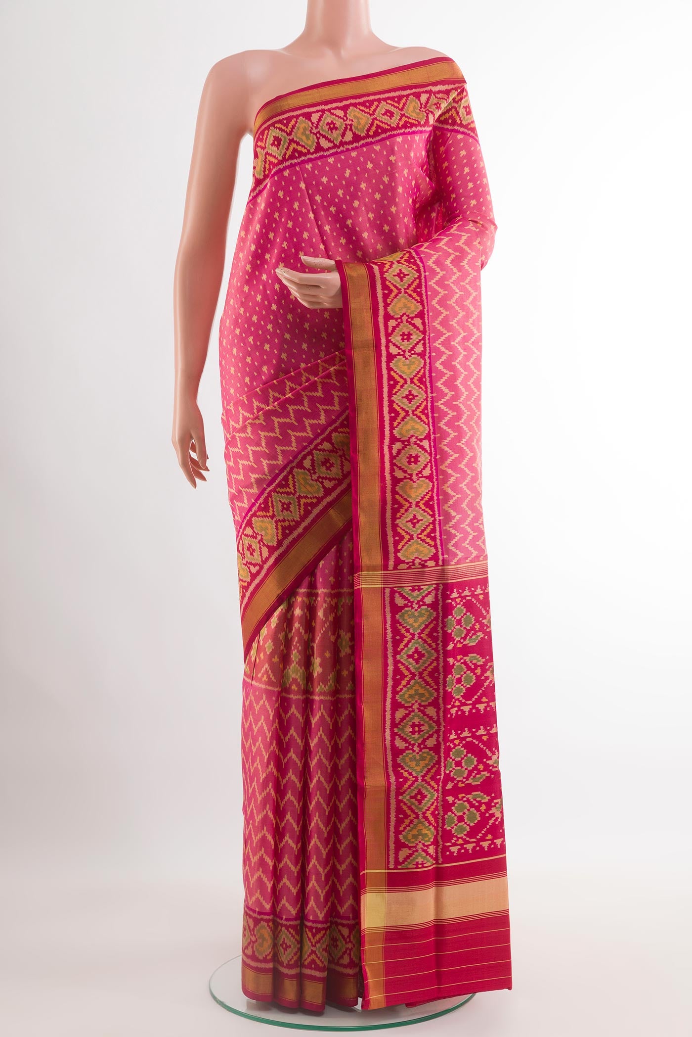 Pink Rajkot Patola Silk Saree with Ikat design on the body and Zari Border.  displayed on a mannequin