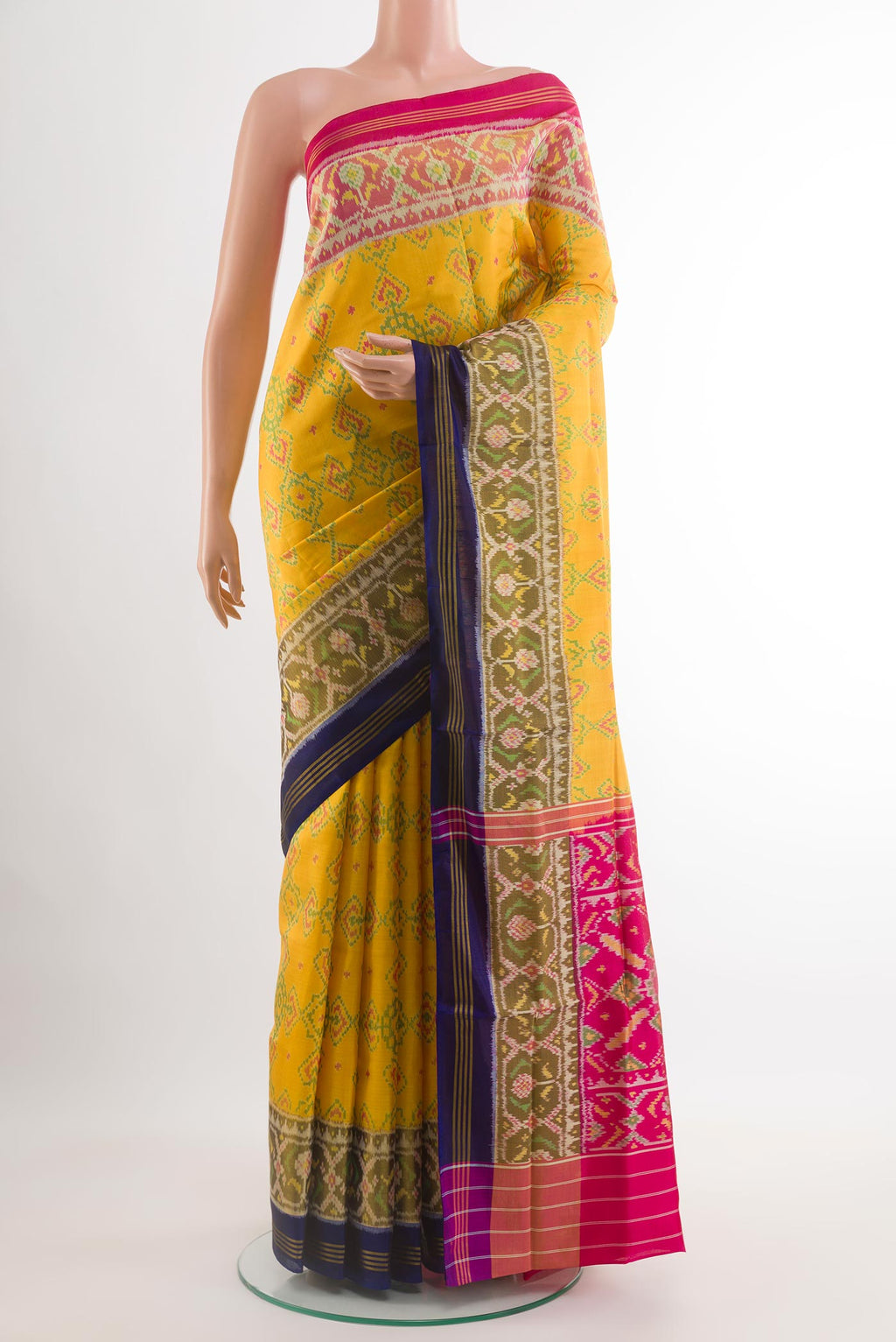 Yellow Rajkot Patola Silk Saree with Ikat design on the body and Zari Border.  displayed on a mannequin