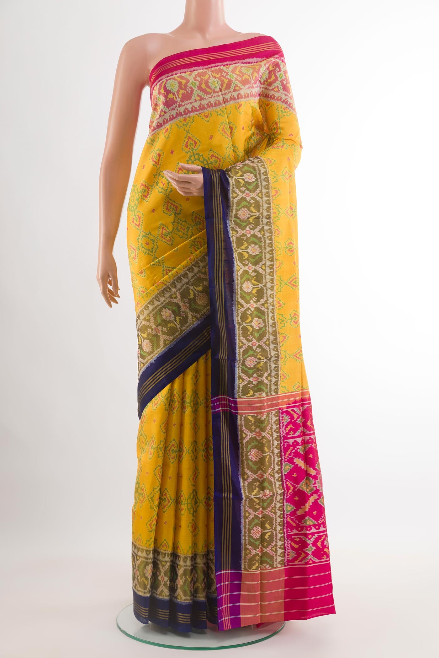 Yellow Rajkot Patola Silk Saree with Ikat design on the body and Zari Border.  displayed on a mannequin