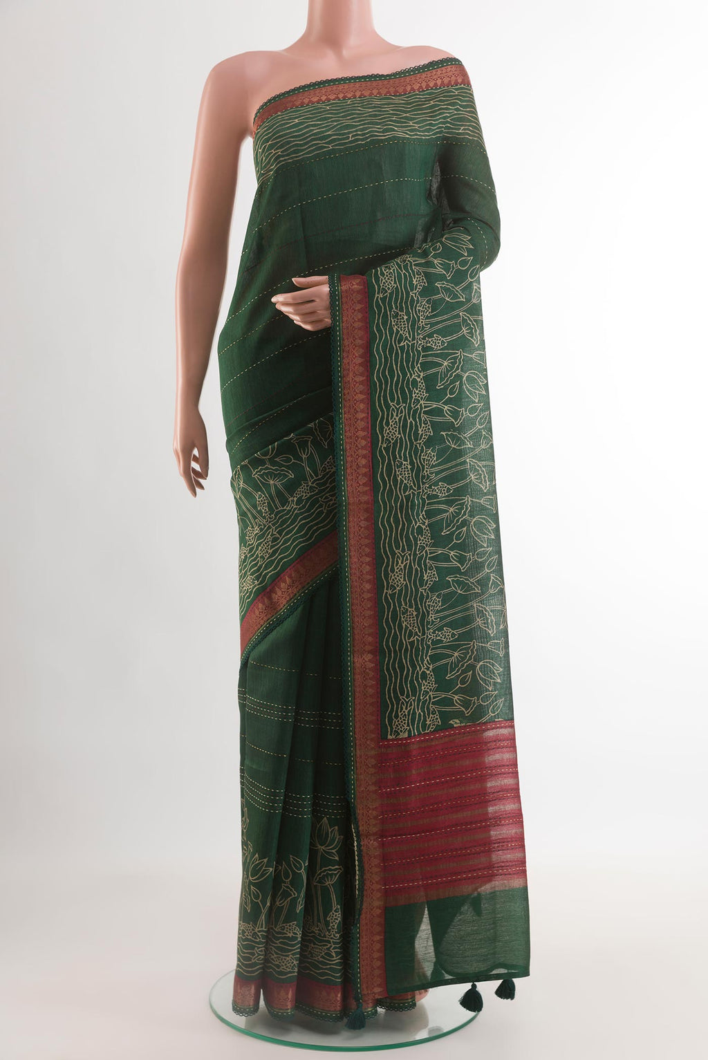 Bottle Green Tussar Silk Saree with Printed design on the body and Zari Border.  displayed on a mannequin