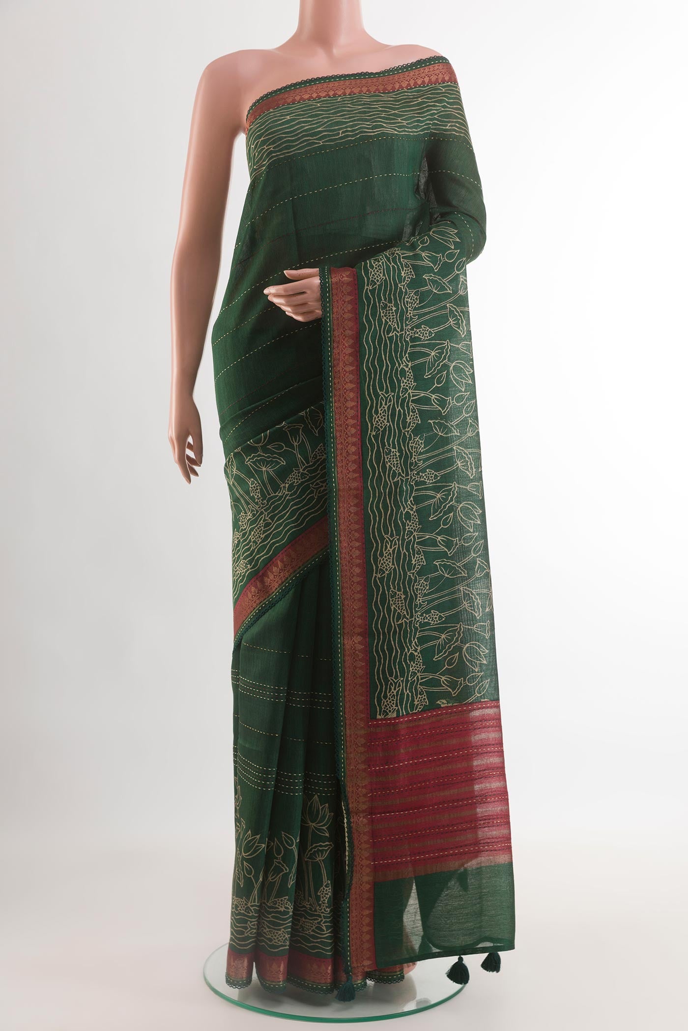 Bottle Green Tussar Silk Saree with Printed design on the body and Zari Border.  displayed on a mannequin