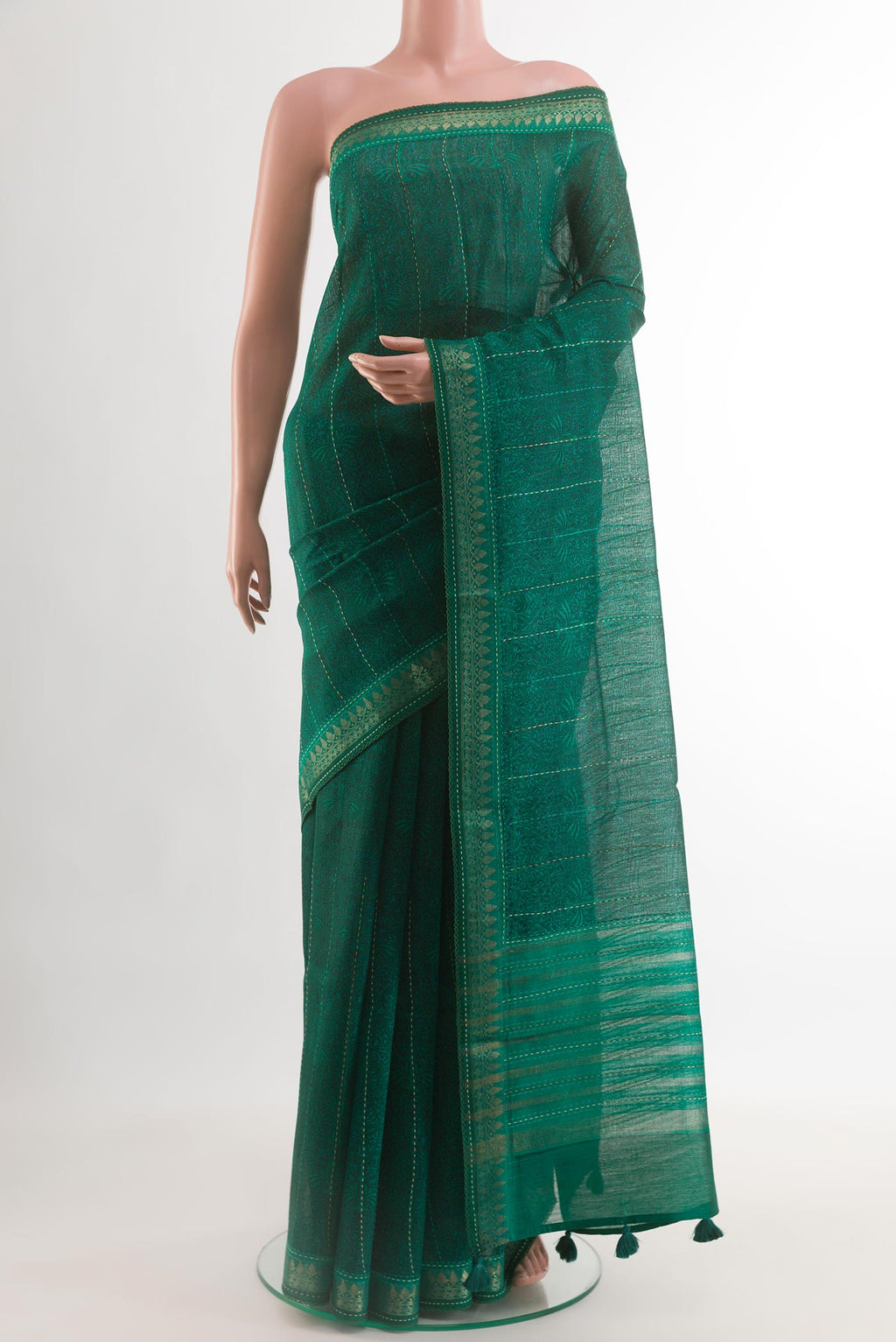 Teal Tussar Silk Saree with Printed design on the body and Zari Border.  displayed on a mannequin