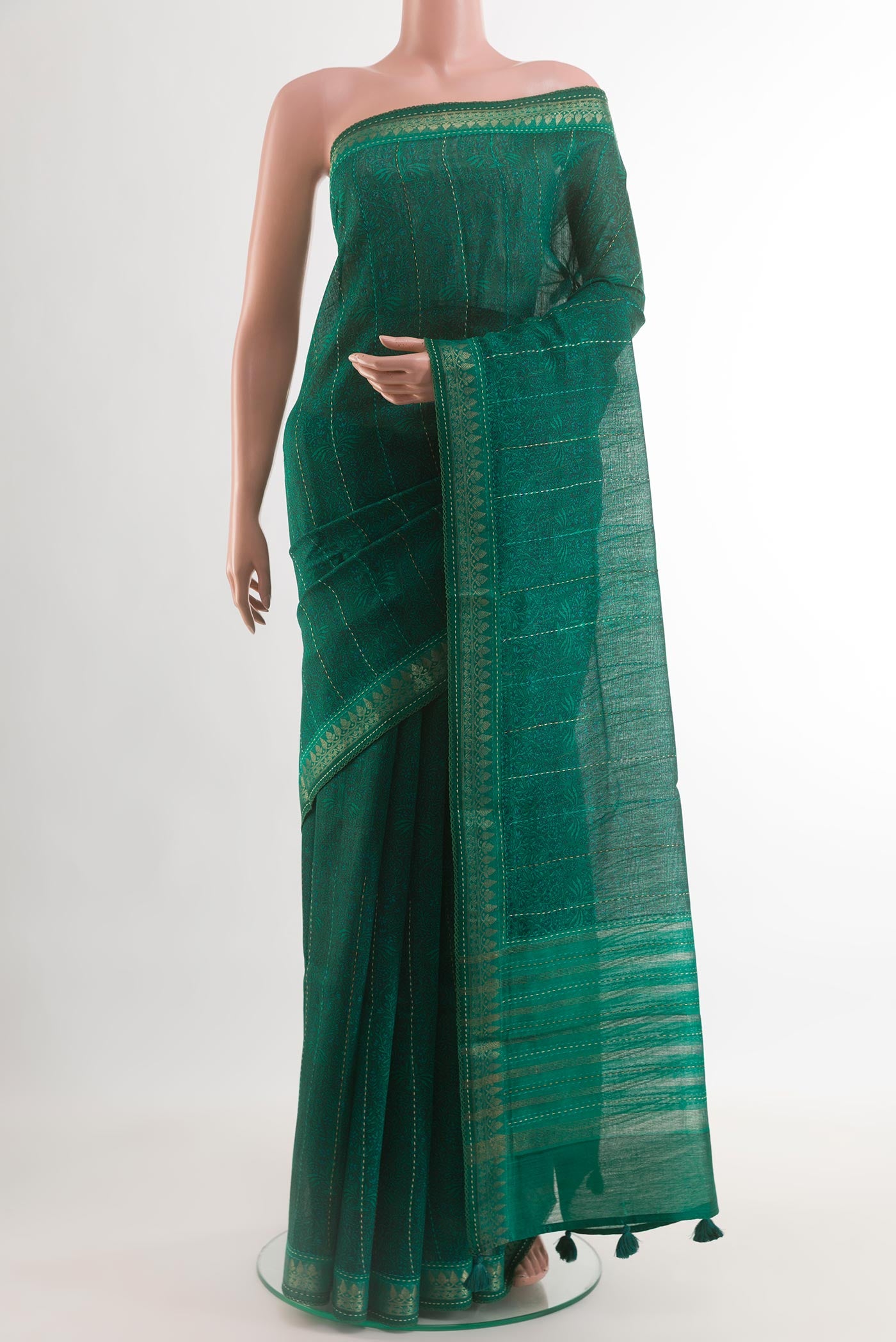 Teal Tussar Silk Saree with Printed design on the body and Zari Border.  displayed on a mannequin
