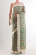 Green Tussar Silk Saree with Printed design on the body and Zari Border.  displayed on a mannequin