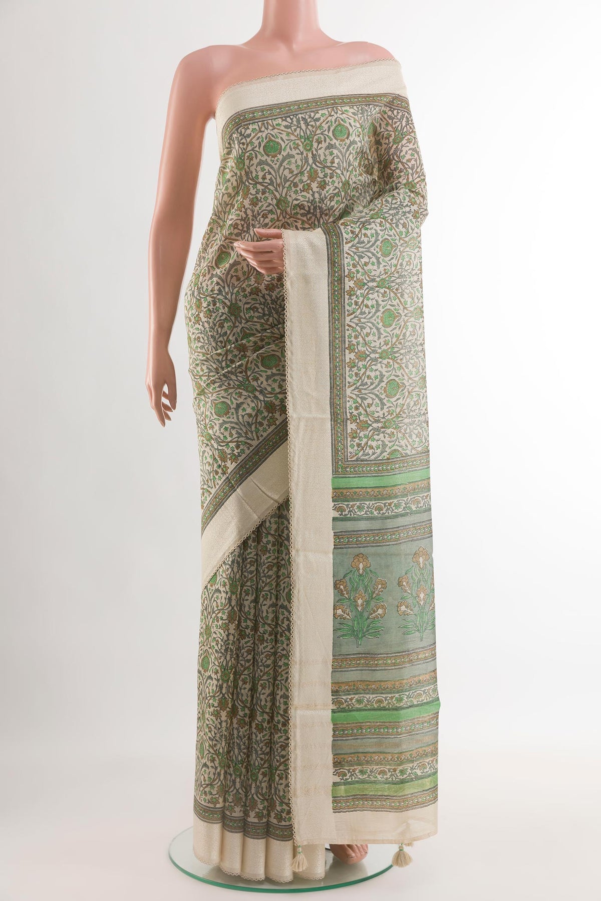 Green Tussar Silk Saree with Printed design on the body and Zari Border.  displayed on a mannequin