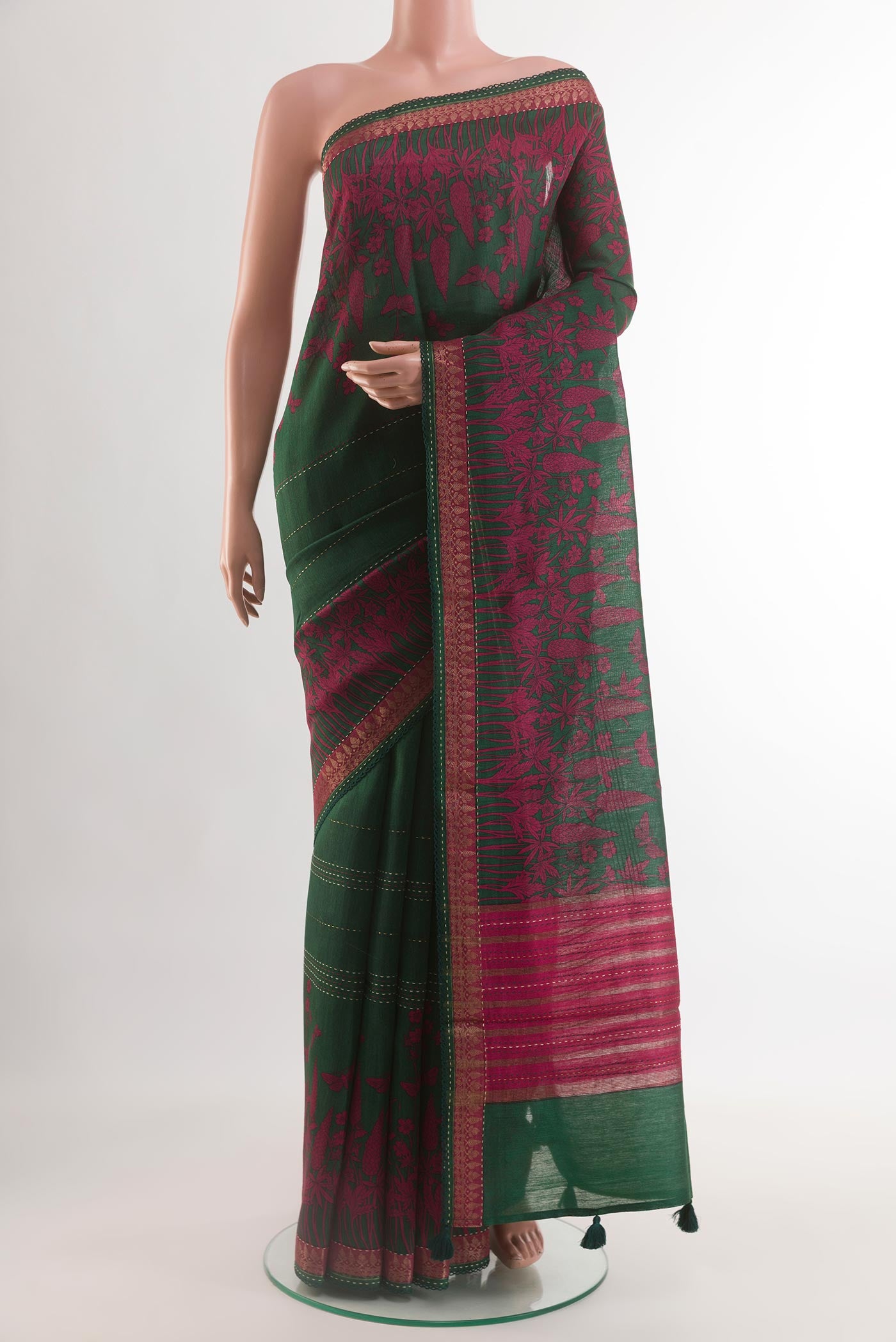 Bottle Green Tussar Silk Saree with Printed design on the body and Zari Border.  displayed on a mannequin