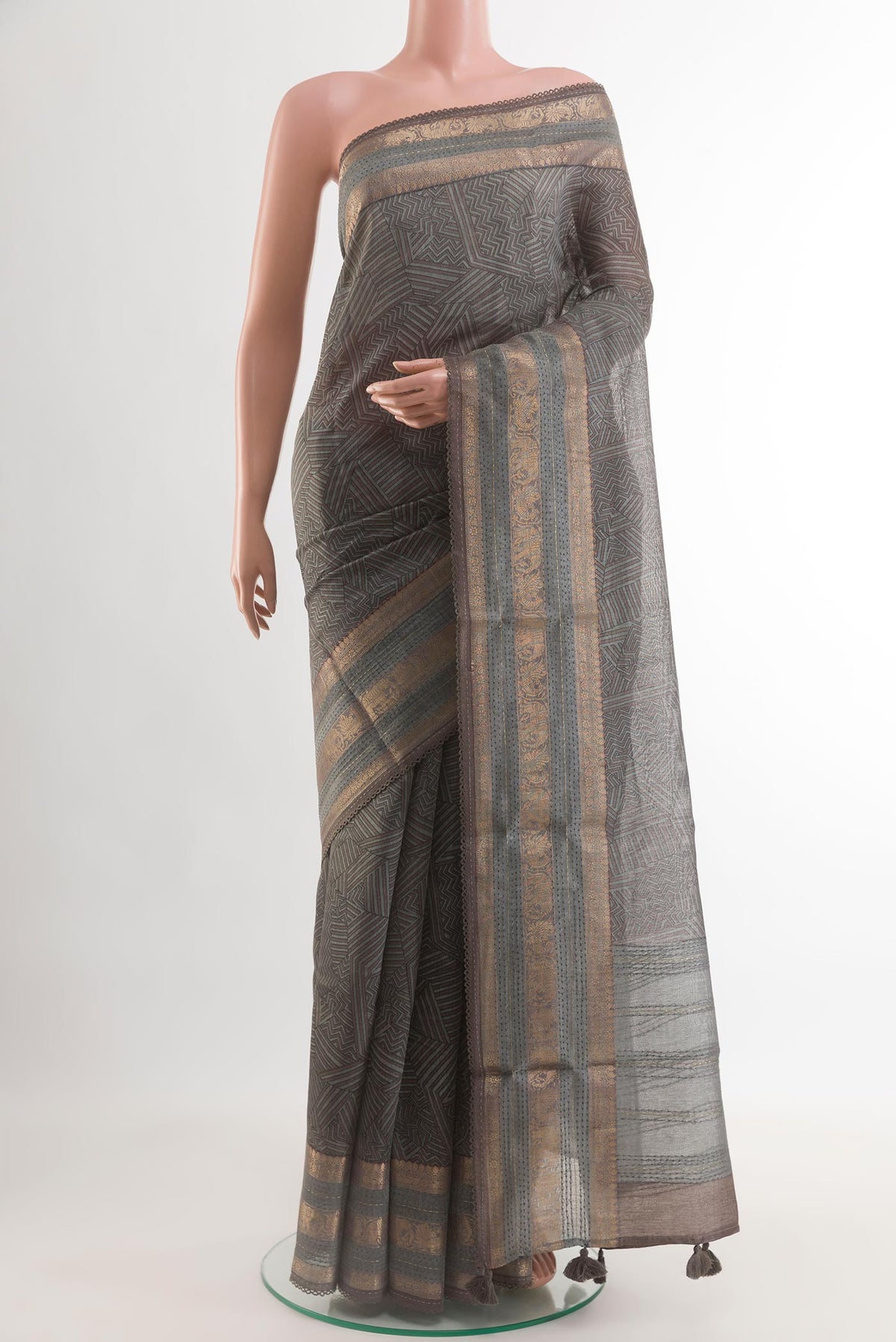 Grey Tussar Silk Saree with Printed design on the body and Zari Border.  displayed on a mannequin