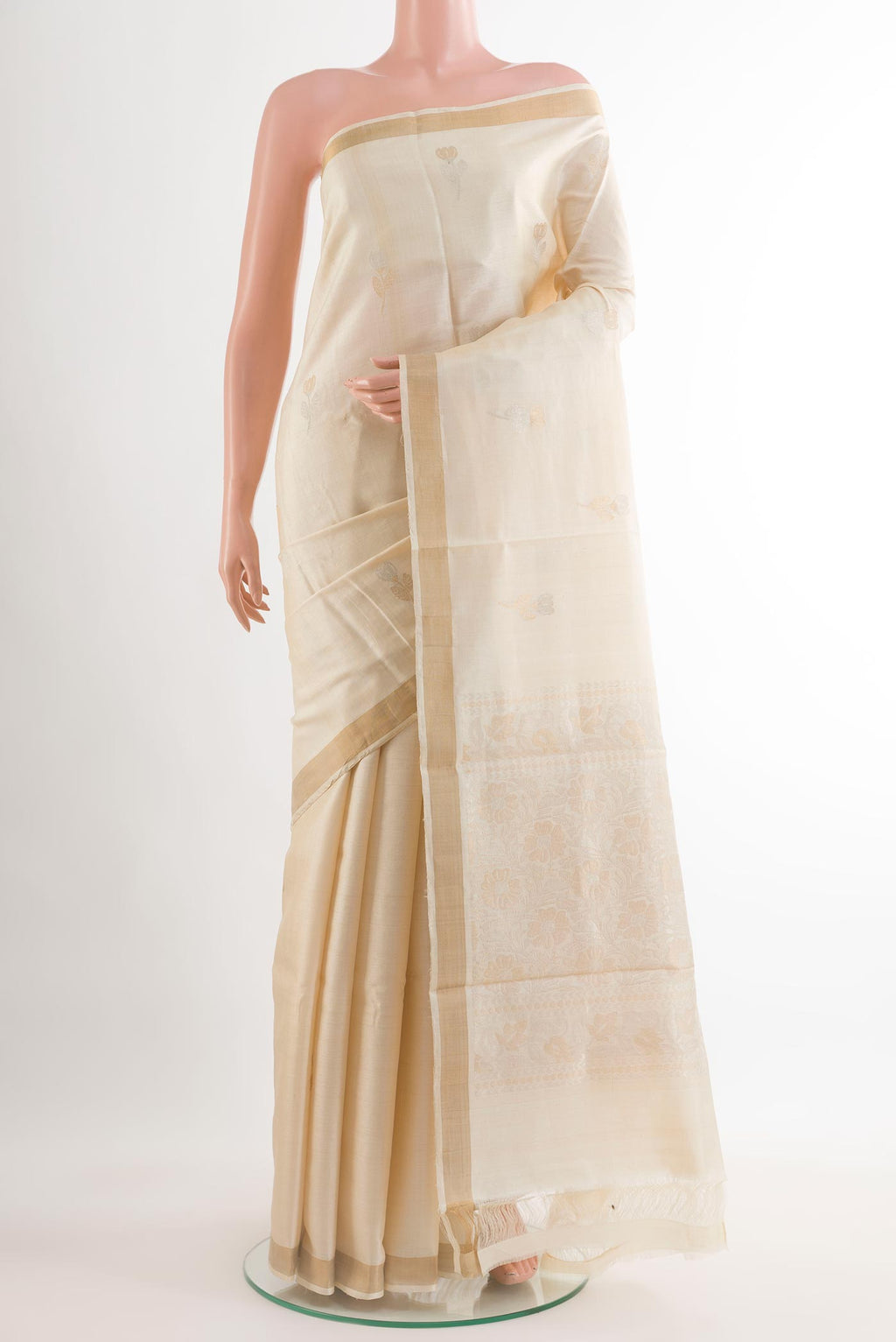 Off White Tussar Silk Saree with Zari Butta on the body and Zari Border.  displayed on a mannequin
