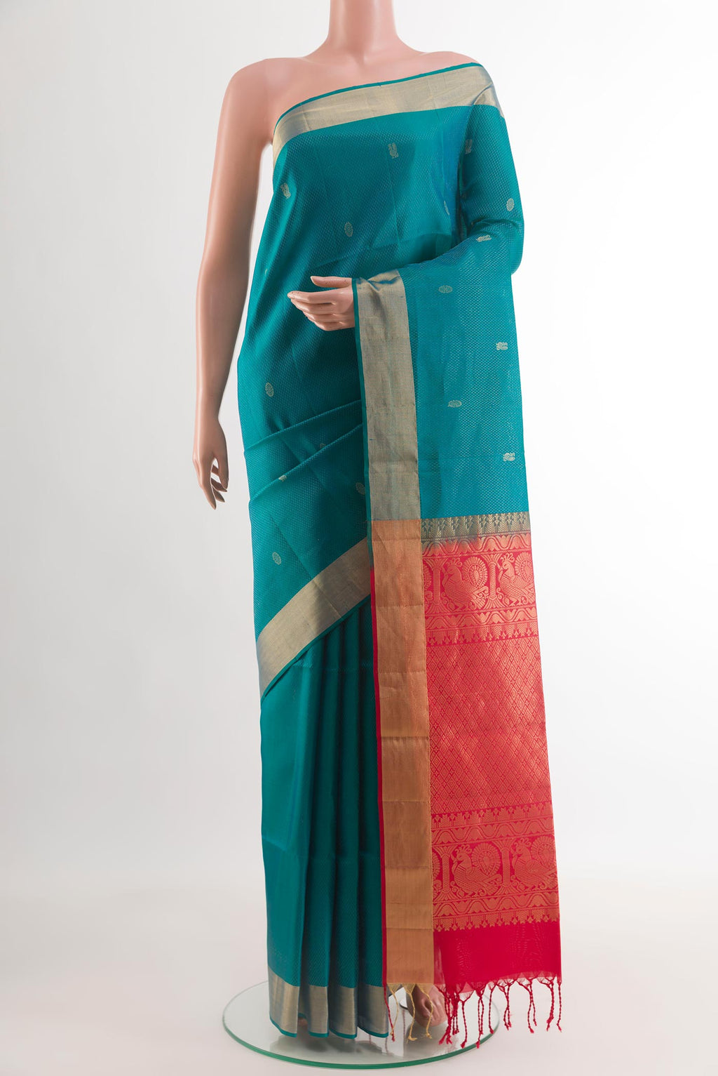Peacock Blue Soft Silk Saree with Zari Butta on the body and Zari Border.  displayed on a mannequin