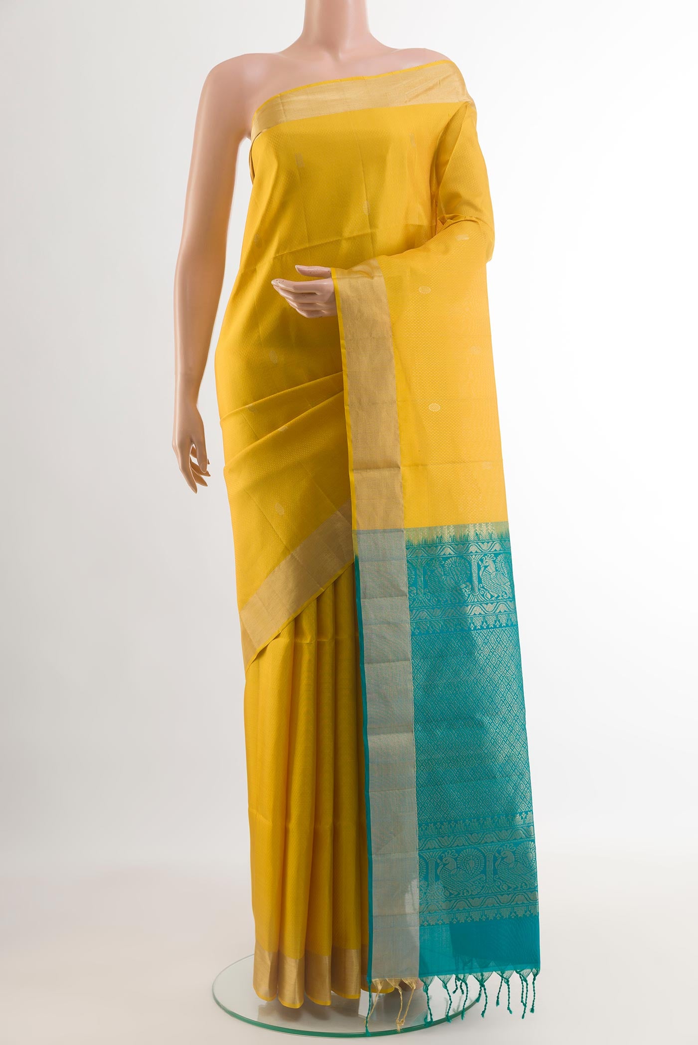 Yellow Soft Silk Saree with Zari Butta on the body and Zari Border.  displayed on a mannequin