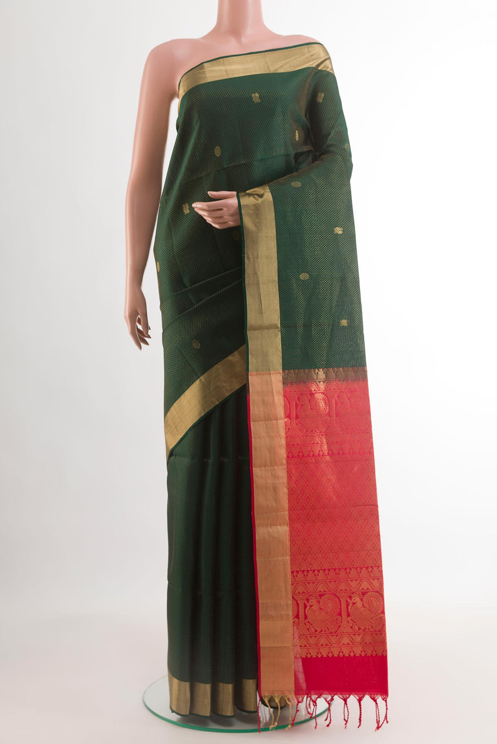 Bottle Green Soft Silk Saree with Zari Butta on the body and Zari Border.  displayed on a mannequin