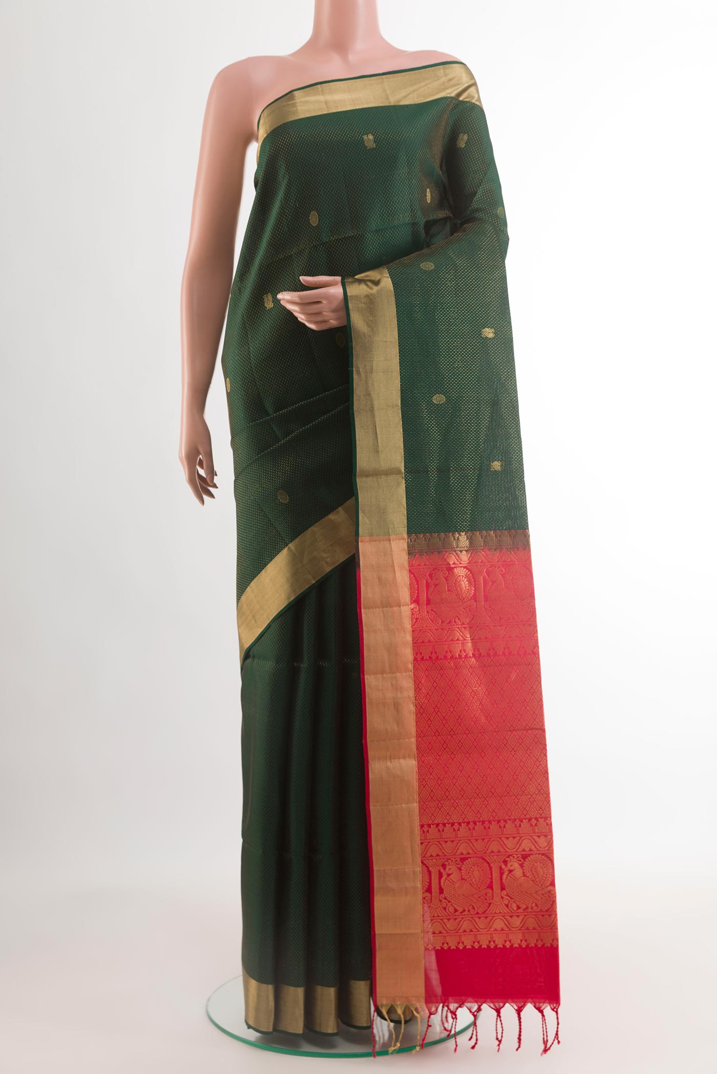 Bottle Green Soft Silk Saree with Zari Butta on the body and Zari Border.  displayed on a mannequin