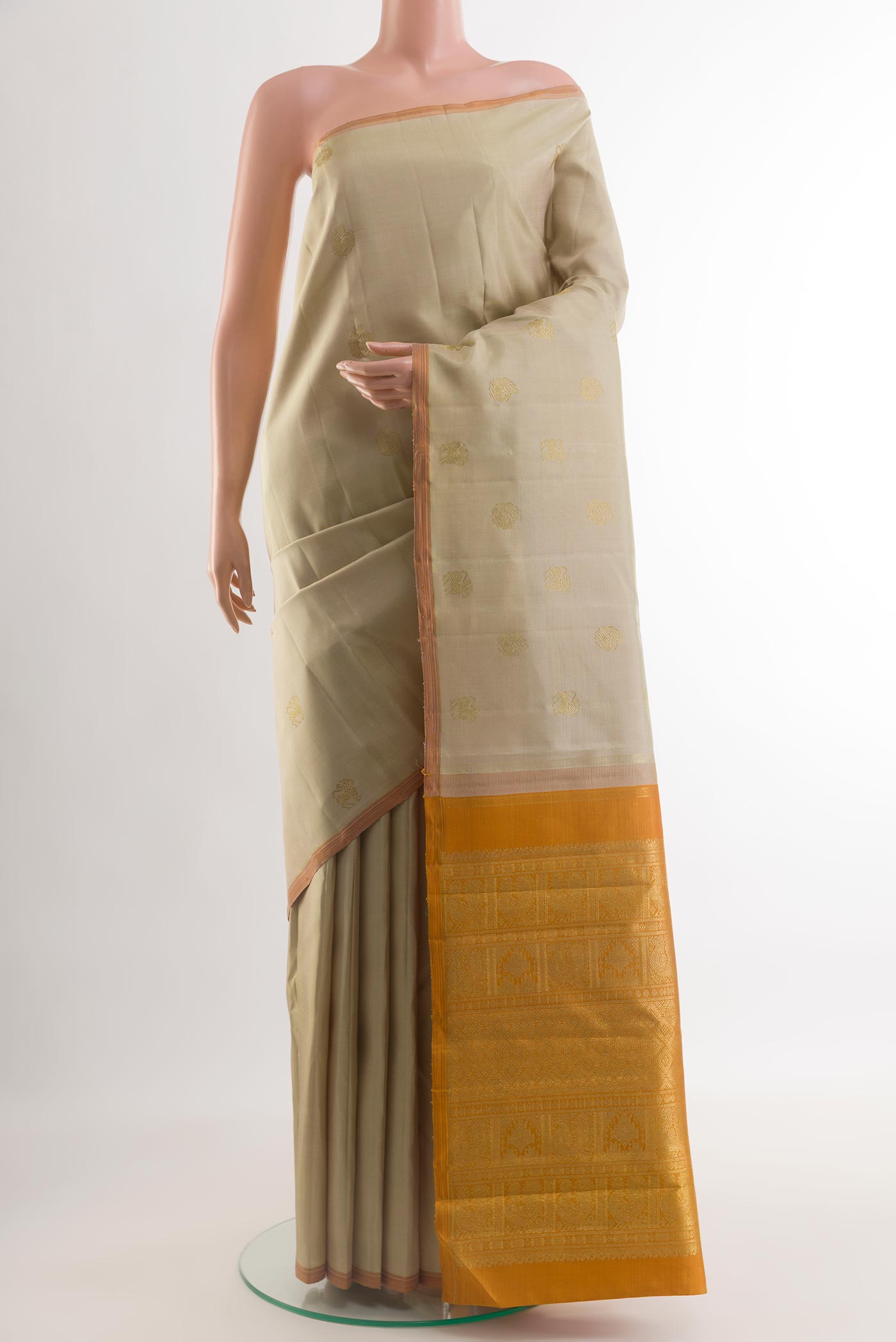 Pure Silk Pure Zari Beige Kanchipuram Saree with Zari Butta on the body and Without Border.  displayed on a mannequin