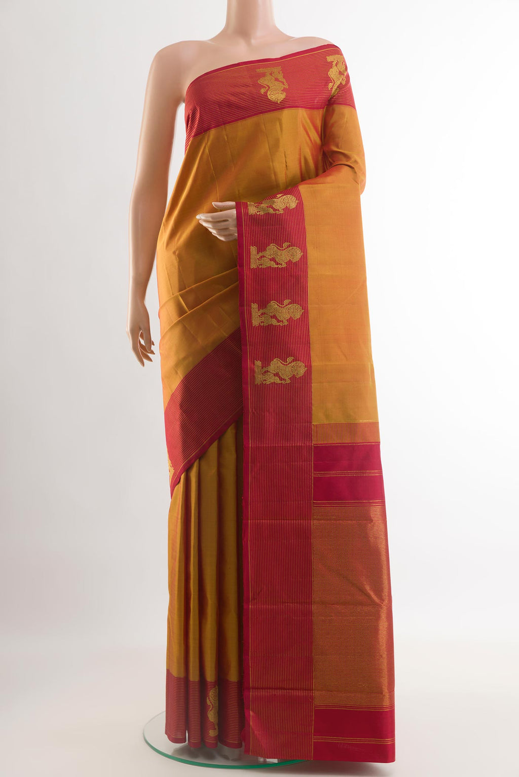 Mustard Kanchipuram Silk Saree with Zari Butta on the body and Zari Border.  displayed on a mannequin